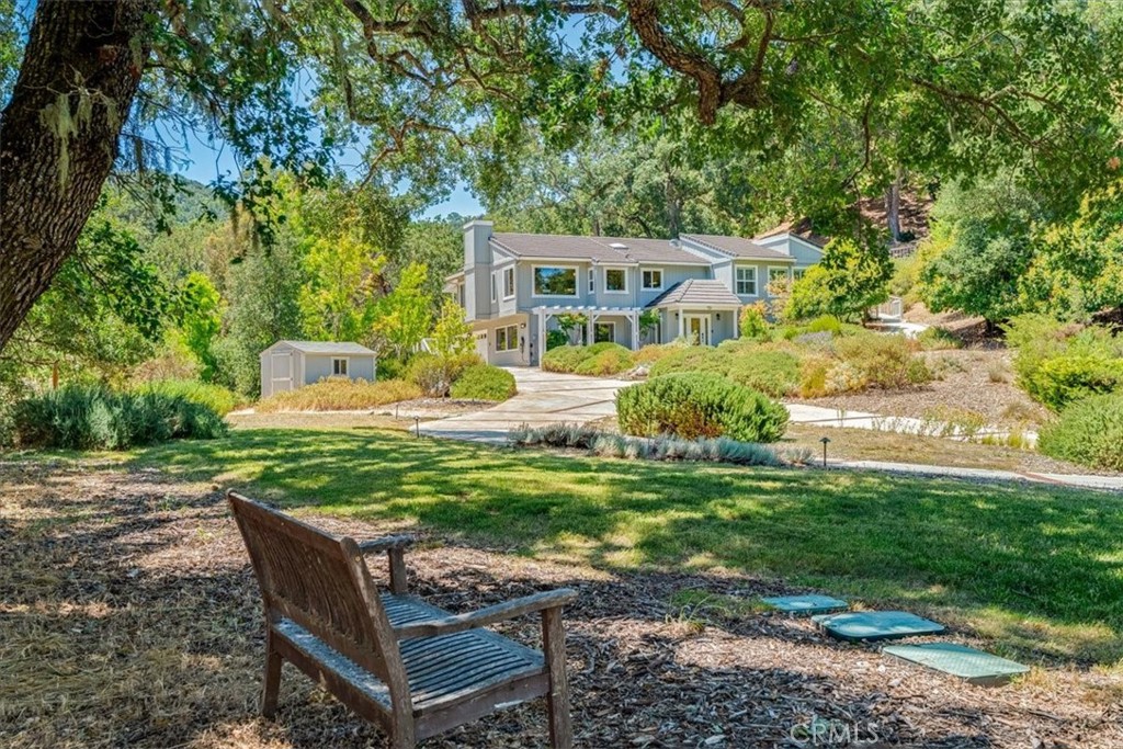 Settled in Paradise Valley in Westside Atascadero on over 7 acres, is this lovely home in a gracious park-like setting. Highlighting the property is a custom landscape design, that accentuates the best of California and local native beauty. With a circular drive and gated entrance, there is ample room for guests and extra vehicles. An elegant flagstone walkway follows the lot topography and makes the upstairs accessible from the driveway with no stairs. The high ceilings and generous floorplan include picture perfect views from nearly every window. In addition to bedrooms on the main level, there are several additional rooms on the lower level, including a spacious bonus room with built-in cabinetry. Serving the property is a solar system of 6.5 kW, fully owned and transfers with sale. The property is served by city municipal water, not a well. The deck design was inspired by a natural waterfall flow and easily transitions living space to the outdoors. Fenced area for farm animals includes a run-in paddock and shed. Don’t miss the food forest with fruit trees, fencing, and a delightful charming decorative gate!
