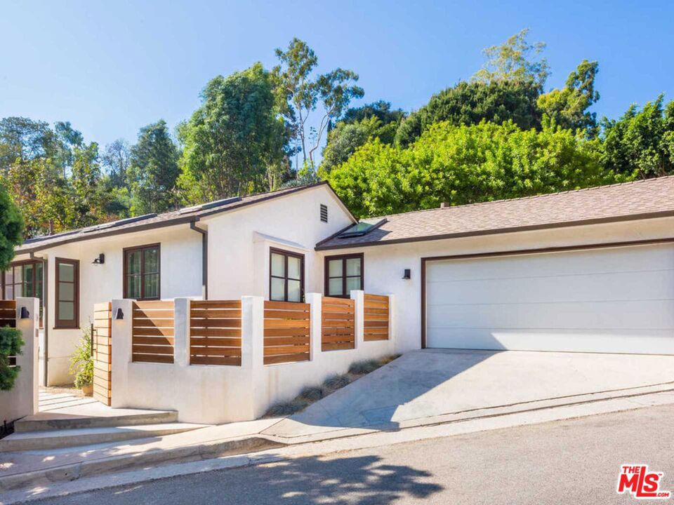 This beautiful Hollywood Hills hideaway is the perfect blend of modern design and understated elegance. Gated and private, this three-bedroom home was re-imagined by the iconic Nicole Sassaman and features open-space design with abundant natural light, bespoke custom cabinetry, gourmet kitchen, en-suite bedrooms, and a beautiful private garden with outdoor barbecue, dining, and fire pit. As smart as it is stylish, this home features cutting-edge technology including Control 4, drop-down hidden projector, built-in sound system, Velux Solar sky lights, and fully integrated Miele appliances. Located on one of the most coveted streets up Beachwood Canyon, this intimate and chic home offers an extraordinary living experience just moments from the heart of Hollywood.