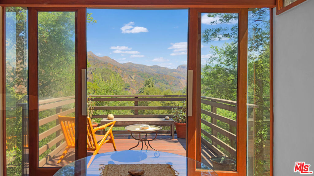 Ideal canyon retreat for one or two - Contemporary treehouse retreat in Fernwood with sweeping cross-canyon and mountain views. Designed to blur indoor and outdoor living, the home spans three levels with expansive glass walls, ocean breezes, and abundant natural light. On the main floor, a spacious living area, dining room, den, and kitchen orient to the canyon. A wood-burning fireplace anchors the living room, and a private deck off the living room captures the views. Upstairs, a lofted office, generous closets, a bedroom, and a bath sit at canopy level, framed by sunlight and treetops. At the entry, a rooftop deck by the carport offers 180-degree canyon panoramas. The ground level adds a secluded hot tub, outdoor shower, and an enclosed flex space ideal for a workshop or studio. Built in 1987 and updated with modern appliances, lush landscaping, motorized solar shades, and split-system AC for year-round comfort and convenience. Tucked near the end of a quiet cul-de-sac in climate-perfect Fernwood. Private and tranquil, yet a short drive to PCH and the center of town. Suitable for one person or a couple. A special place where tranquility, style, and convenience are held in one peaceful place.