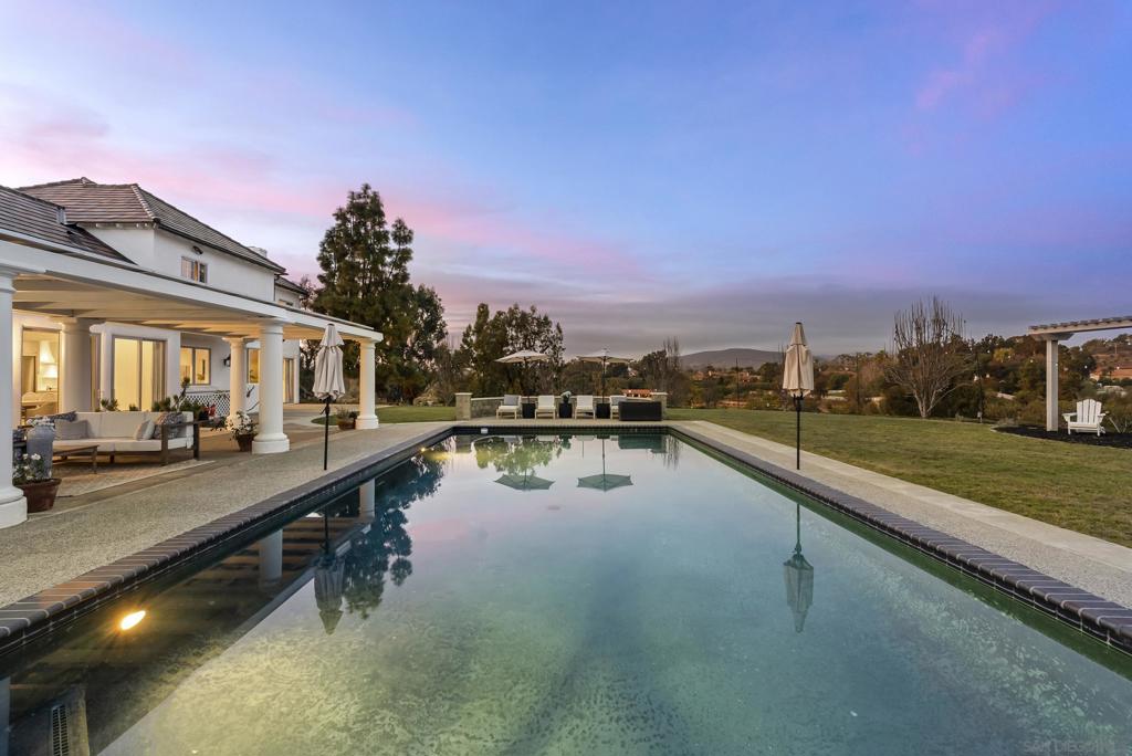 Nestled in the only gated community within the prestigious Rancho Santa Fe Covenant, this exceptional estate offers an unparalleled blend of luxury, comfort, and timeless craftsmanship. Positioned on the coveted Covenant trail system, this residence seamlessly connects you to scenic equestrian paths, lush landscapes, and the best of Rancho Santa Fe living. Designed to embrace effortless single-level living, the home spans approximately 4,200 square feet on the first floor alone, with an elegant layout that invites both grand entertaining and intimate gatherings. Expansive windows capture breathtaking views, creating a tranquil retreat in the heart of nature. Meticulously remodeled with custom oak cabinetry and the finest natural materials—including exquisite marbles and quartzites—this home radiates warmth and sophistication. The gourmet kitchen is a chef’s dream, featuring an Ilve stove, two dishwashers, and a striking plaster range hood that blends old-world charm with modern functionality. The primary suite is a sanctuary of relaxation, boasting a luxurious steam shower and a Jacuzzi tub with an onboard heater, while thoughtfully integrated laundry baskets in the bathrooms add a touch of everyday convenience. Beyond the main residence, a detached studio apartment offers endless possibilities—ideal for guests, a home office, or a private retreat. Additional features include new irrigation, elegant plaster fireplaces, and a seamless indoor-outdoor flow that enhances the serene Rancho Santa Fe lifestyle.