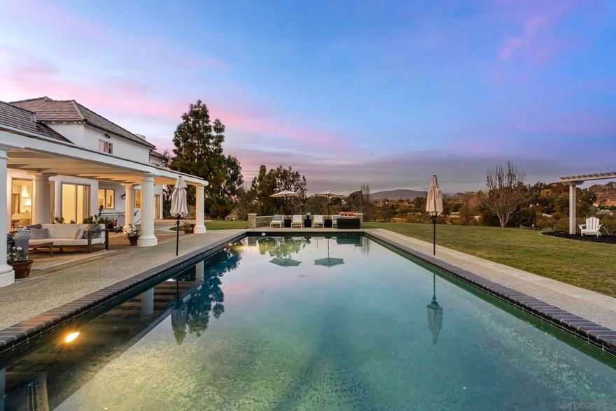 Nestled in the only gated community within the prestigious Rancho Santa Fe Covenant, this exceptional estate offers an unparalleled blend of luxury, comfort, and timeless craftsmanship. Positioned on the coveted Covenant trail system, this residence seamlessly connects you to scenic equestrian paths, lush landscapes, and the best of Rancho Santa Fe living. Designed to embrace effortless single-level living, the home spans approximately 4,200 square feet on the first floor alone, with an elegant layout that invites both grand entertaining and intimate gatherings. Expansive windows capture breathtaking views, creating a tranquil retreat in the heart of nature. Meticulously remodeled with custom oak cabinetry and the finest natural materials—including exquisite marbles and quartzites—this home radiates warmth and sophistication. The gourmet kitchen is a chef’s dream, featuring an Ilve stove, two dishwashers, and a striking plaster range hood that blends old-world charm with modern functionality. The primary suite is a sanctuary of relaxation, boasting a luxurious steam shower and a Jacuzzi tub with an onboard heater, while thoughtfully integrated laundry baskets in the bathrooms add a touch of everyday convenience. Beyond the main residence, a detached studio apartment offers endless possibilities—ideal for guests, a home office, or a private retreat. Additional features include new irrigation, elegant plaster fireplaces, and a seamless indoor-outdoor flow that enhances the serene Rancho Santa Fe lifestyle.