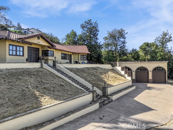 This architect-designed masterpiece is a serene retreat-view home in the city of the West Hills, blending artistic vision with natural tranquility. The bold exterior hints at the meticulous design within. This 5-bedroom, 4-bathroom residence has an open and bright floor plan with walls of windows that flood the interior with natural light, mountain and canyon views, seamlessly blending indoor and outdoor living. The main level showcases a huge living room, a family room with a fireplace, and travertinefloors. The dining room offers wraparound views of the mountains, canyons, and Chatsworth reservoir. The den is an entertainer’s dream, boasting a large kitchen with custom cabinets. Designed for multi-generational living, the flexible floor plan offers four independent living spaces, kitchens, and laundry areas, with heavy woodendoors for added privacy. The primary suite is a true sanctuary, featuring a retreat area, plus a sunken spa tub that transforms into a tranquil water feature. At night, the window perfectly frames Chatsworth hills and Porter Ranch views. The spa-like bath boasts European cabinetry, a walk-in closet with travertine/slate flooring throughout. The second ensuite bedroom offers expansive closets and stunning mountain views, while shower windows frame the landscape. Approximately 1200 sqft guest house away from the main house for extra privacy, with living room, 3 Bedroom and 2 bath, kitchen, and private patio, and windows framing a peaceful lanai, and captures sunrises over the Chatsworth hills and Porter Ranch-- perfect for extended family stay, in-laws quarters, maids quarters, guests or an income opportunity. A huge pool, spa and large area for BBQ, entertaining, and family gatherings. Beyond the sundeck lies lush hillside grounds already flourishing with a 360 mountain and hill view, charming garden, trees, with remaining land, your creative possibilities are endless whether it's your own private orchard, a peaceful meditation sanctuary, or even a sport court. 3-car garage, and driveway for 10 or more cars, RV, boat, trailers,parking, etc. This home is conveniently located near grocery stores, shopping centers, fine dining, public transportation, Topanga Village (less than 10 minutes away), the 101 & 118 Freeways. This is more than a home—it’s an architectural masterpiece designed for luxury, tranquility, and inspired living. Once in a lifetime kind of home. Must See!!!
