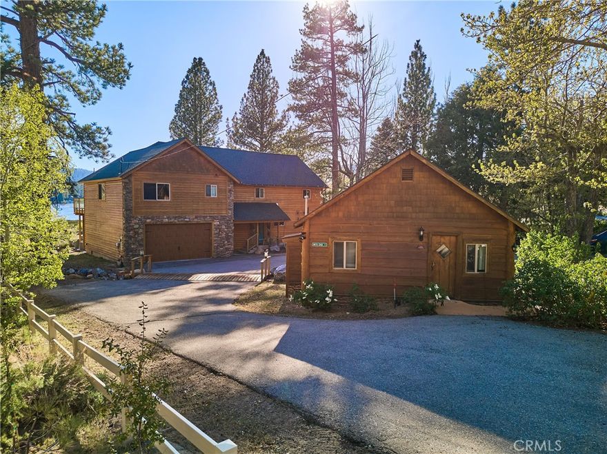 Tucked along the tranquil shores of Big Bear Lake's Metcalf Bay, this rare multi-unit lakefront property is rich in history, nature, and opportunity. Purchased by the family in 1975, it became Harbor Cove Resort, once home to ten charming cabins. Many of the home’s distinctive features were reclaimed from those cabins and thoughtfully incorporated into the current residence, which was completely rebuilt and expanded in 2016. The main home offers a spacious kitchen/dining/family area upstairs with additional play and game areas, 5 bedrooms—including two master suites, one with a stone fireplace—3.5 bathrooms, and an elevator for full accessibility. A detached 1890’s cabin, updated in 2009, adds 2 bedrooms and 1 bath, perfect for guests, personal use, or long-term rental potential. Set on more than half an acre of prime lakefront land, the property features a unique channel trench dug with neighboring owners to allow boat access even during low-water years. Surrounded by soaring pines and panoramic lake views, the grounds include a whimsical wheelchair-accessible miniature golf course, wandering creek, and expansive decks and pavilion to enjoy eagle and heron sightings. As a plus, the adjacent neighbor has been open to sharing dock space. Whether you’re seeking a legacy estate or a versatile mountain retreat, this is a one-of-a-kind offering with unmatched land and water access in Metcalf Bay. Seller is motivated and open to all offers.