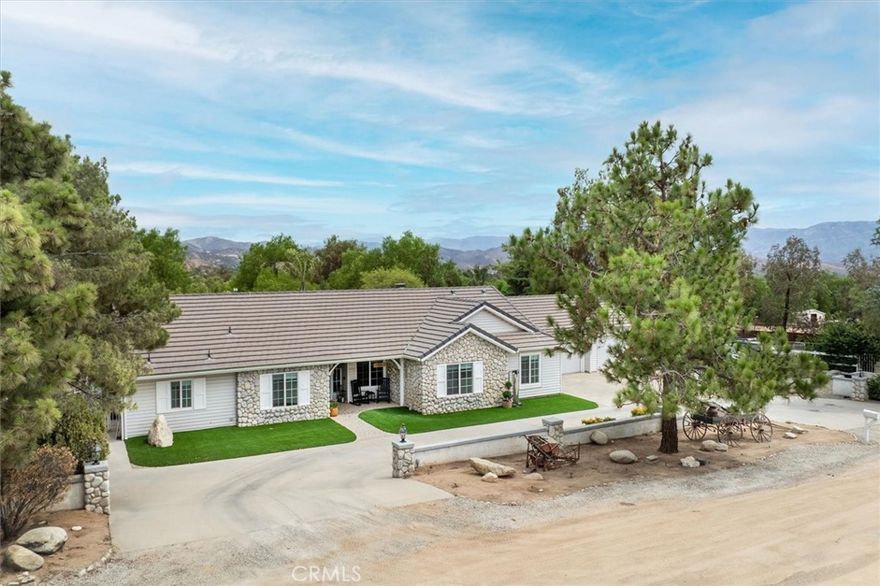 Welcome to North Trail Ranch Estates in the heart of Agua Dulce, where this beautifully updated single-story ranch sits on a fully fenced and level 2.5-acre lot designed for both luxury living and equestrian enjoyment. From the moment you arrive, you’ll be captivated by the gorgeous curb appeal—all paved access roads lead to a circular driveway with mature trees, 2 gated entrances, RV parking, and a 3-car attached garage with its own A/C system. Step inside to a bright, open layout with vaulted ceilings and luxury vinyl flooring throughout. Remote-controlled Roman shades add modern comfort, while the living, dining, family room, and kitchen flow seamlessly together, creating a warm and inviting atmosphere. The chef’s kitchen is a true standout, featuring a Sub-Zero refrigerator, wine fridge, & professional Thermador stove/oven. Granite counters, a farm-style porcelain sink, and upgraded cabinetry with pullouts and soft-close features provide both beauty and practicality. A large center island with bar seating and additional cabinetry along the dining room wall ensures abundant storage. The kitchen opens to the family room, complete with a cozy fireplace with newer gas logs, custom mantel, and views of the backyard pool. The split floorplan places 2 secondary bedrooms with ceiling fans and a shared hall bath on one side of the home, while the private primary suite sits on the other. This retreat offers vaulted ceilings, sliding door to the backyard, and a spa-like bathroom completely remodeled within the past year. The primary bath showcases custom hand-carved vanities imported from Turkey topped with elegant sinks from Poland, a soaking tub, and a beautifully tiled shower. A den/4th bedroom is conveniently located off the entry, offering flexible use as an office, gym, or guest room. Step outside to your backyard oasis, highlighted by a sparkling pool and spa with waterfall and new heater, a large covered patio, built-in BBQ, firepit, and lush artificial turf. Equestrian amenities include a 3-stall barn, tack room, wash area & water and electricity throughout. The property also features a fully secured lighted riding arena, multiple gated pens/enclosures, 2 storage sheds, and extensive hardscape and irrigation improvements. Additional features include a whole-house fan, a whole-house water filtration system, tankless water heater, newer furnace, fresh interior paint, and more than $100,000 in improvements within the past year. This one won't last!