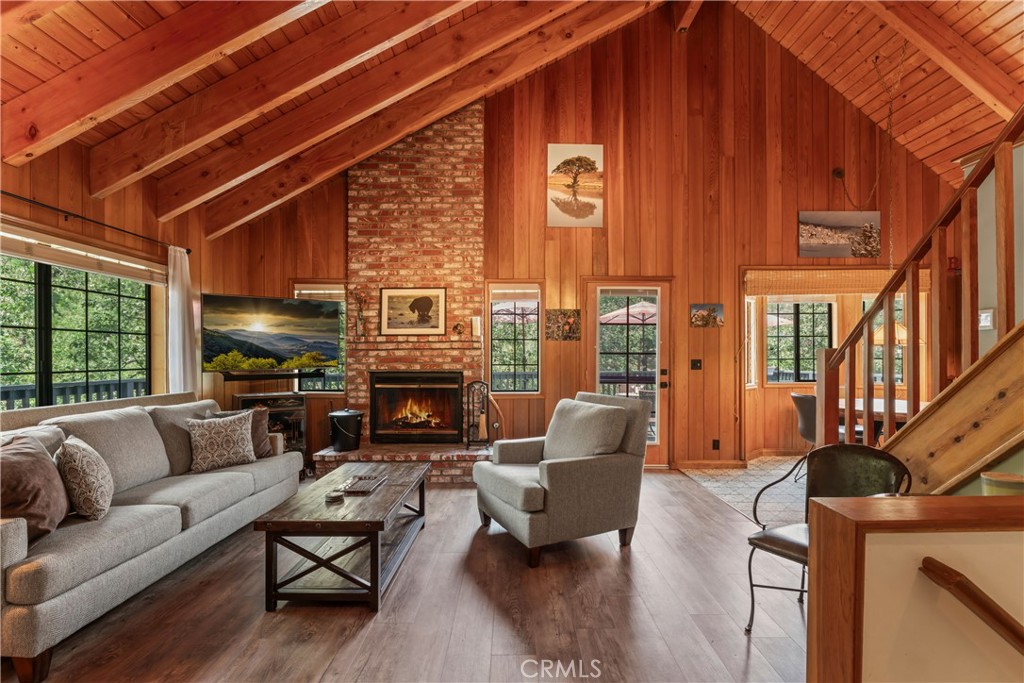 Lake Rights, Street Level Entry, County Plowed & Maintained Cul-De-Sac, No Deferred Maintenance, Two-Car Parking on Flat Paved Driveway. Stunning finishes, thoughtful design, and sun-soaked serenity – this Lake Arrowhead gem checks every box. Enjoy vaulted beamed ceilings, Calacatta herringbone marble bath, quartz counters, newer kitchen cabinetry, luxury vinyl floors, beautiful kitchen tile floor, 4-zone HVAC system, tankless water heater, dual-paned windows, and solar panels that cover electricity. The high-end finishes throughout shine. Ideal layout: 2 beds/1.5 baths on main, 1 bed/1 bath + murphy bed below, plus a versatile loft that can accommodate two twin beds or office set-up. Two large decks overlook a seasonal creek and wooded setting. Most furnishings come with the house including the refrigerator, washer/dryer, living room & dining room furniture, bedroom furniture, etc. making this a turnkey opportunity. Located in an area of Lake Arrowhead that has less snow to shovel. This is the kind of home that leaves a lasting impression – refined & relaxed.