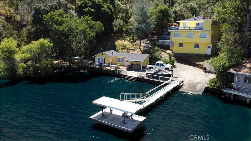 LAKEFRONT WITH TWO HOMES Five bedroom, two bath main home, one bedroom, one bath guest house. Covered dock, boat slip with winch, 100 ft water frontage on a deep water cove with no neighbor on one side. Perfect family-sized vacation getaway or permanent home, with potential for income with separate guest home for either short or long term. Laminate flooring, tile baths, custom concrete counter tops. Wood stove with natural stone backdrop. Family room for games and movies. Wrap around decks opening off the living room, including an outdoor deck bar to take in the spectacular natural location with total seclusion and quiet. This is the place where you can really let go, on your own, or with friends and family. Memories to be made here. Move in ready, wrap around decks. Brand new roofs on both homes. Catch fish from your own property, or easily get out on the water and explore California's largest natural lake within its borders.