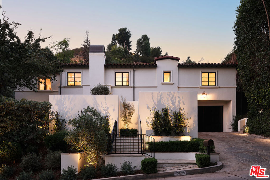 Discover the enchanting allure of old-world charm seamlessly intertwined with modern luxury at 1427 Bluebird Ave, a serene escape nestled in the prestigious Bird Streets. Reimagined by the renowned House of Rolison, and styled in partnership with Olive Ateliers, this 3,855 sq. ft. sanctuary is gated for privacy and offers 4 bedrooms and 5 bathrooms. It radiates timeless beauty with exquisite details and natural earthen materials used throughout, creating an organic and elegant atmosphere. As you step inside, past the wood-paneled entry, the heart of the home draws you in - a chef's kitchen featuring a La Cornue oven, energy-efficient appliances and a charming built-in breakfast nook, perfect for leisurely mornings. The inviting living room bathes under a skylight - with a gas fireplace and access to the lush backyard, beckoning for a quiet evening. Drift through the arched doorways into the romantic dining room and stunning custom built-in bar, setting the stage for effortless entertaining. Upstairs, the primary suite is a true haven of tranquility. Relax on a private balcony, wrapped in fragrant floral and ivy walls, overlooking a soothing water fountain. The suite also boasts a vaulted, wood-beamed ceiling, a cozy gas fireplace, a sitting area, and a spa-like bath with a soaking tub, dual sinks with marble-framed mirrors, and walk-in closet. Two additional guest suites share the upper floor, along with a convenient laundry room, and treetop views. Step outside to be transported to the European countryside. Dine al fresco beneath the stars, surrounded by lush blue plumbago, as gentle breezes and the sound of a trickling fountain envelop you in serenity. A grassy area, outdoor fire pit and heated Zellige tile plunge pool with a Sonos surround system offer the perfect spots to relax or host unforgettable evenings. Crafted with natural materials and custom built-ins throughout, every element of this home has been thoughtfully curated. 1427 Bluebird Ave is more than a residence - it's a dreamscape, blending elegance, warmth, and the timeless allure of a faraway retreat.
