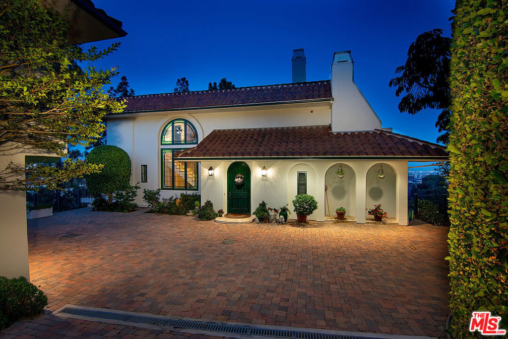 The quintessential private hideaway situated on an over 33,000 sq.ft. lot in Beverly Hills proper w/incredible city views. Enter through gates down a private driveway to the large motor court & 3-car garage. Step into the charming foyer leading into the open living room & adjoining dining area w/fireplace & walls of French doors overlooking the shimmering city views. The spacious country kitchen is complete with center island, professional appliances, & breakfast nook w/fp. Ascend the staircase to the lower level featuring a guest bdrm suite, office w/built-ins, & the tremendous master suite w/fp, dual baths, walk-in closet, & French doors leading to the sparkling lap pool & spa. The top floor offers great space for entertaining including family room w/fp, large built-in bar, & deck overlooking the breathtaking city lights. There is a fabulous detached guesthouse above the garage with private entrance, kitchenette, & bathroom. Quiet & serene living in the City of Beverly Hills!