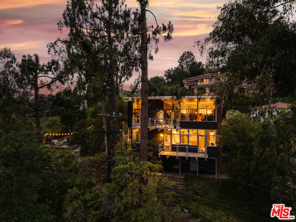 Perched on a serene, private double lot in the heart of Chevy Chase Canyon, 2980 Edgewick Road is a rare opportunity to own an authentic post-and-beam mid century modern masterpiece, designed and built by Joseph L. Johnson, son of renowned architect Reginald Johnson (Biltmore Hotel, Miraflores Estate). This architectural gem has been immaculately maintained, seamlessly blending timeless design with modern updates. Expansive floor-to-ceiling windows flood the interiors with natural light while offering panoramic views of the Chevy Chase Country Club golf course, surrounding mountains, and lush canyon landscapes. Inside, you'll find bamboo flooring, refined architectural detailing, and a spacious, contemporary kitchen. The home is fully smart-enabled, allowing control of HVAC, irrigation, and security systems directly from your phone. Outdoor living takes center stage, with multiple decks, sprawling patios, and a ground-level garden space perfect for alfresco dining or lounging. A detached recreation room offers flexible living - whether as a guest suite, office, or studio - with architect-drawn plans available for a potential ADU conversion (buyer to verify with the city). Additional highlights include updated systems: interior and exterior repainting (2025), a newly redone driveway and carport (2025), and updated plumbing beneath the house (2024). Located on a quiet street in the highly sought-after Glendale Unified School District, this is a truly unique offering.
