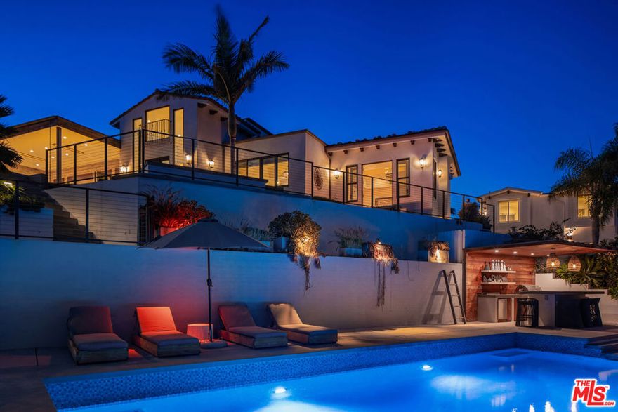 Sited near Point Dume, in the heart of Malibu, this gated, ocean view compound embodies five-star resort-style living and is configured to entertain. On a private half-acre, the grounds are designed to inspire both connection and escape, offering spaces to gather, unwind, thrill seek, and fully embrace the Malibu lifestyle. A large pool and jacuzzi accomodate relaxation, while expansive flat lawns provide ample room for play. With ocean views from nearly every vantage point, the single-story main residence consists of five bedrooms, seven bathrooms, plus an office/gym. Outdoor fireplaces and the poolside bar set the stage for evenings under the stars, while Tulum-inspired hideaways tucked behind lush, flowering entrances provide sites for meditation. The primary suite is a retreat of its own, complete with dual walk-in closets, a large soaking tub, and an oversized shower. The kitchen is equally impressive, outfitted with top-of-the-line Viking appliances and an oversized island. Complementing the main house, a detached two-story guest residence offers a private bedroom, living area, kitchenette, and full bath, creating a separate suite for visitors. Mature avocado, fig, lime, and lemon trees decorate the perimeter.  A built-in trampoline, private skate park, and close proximity to some of SoCal's best surf breaks promote an active Malibu lifestyle. Motor-court parking and no neighbors on three sides of the property. All this, only moments from Soho Little Beach House, Nobu, and all that Cross Creek Living has to offer.