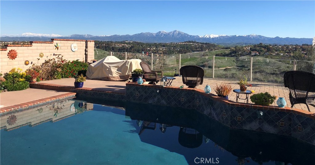 PANORAMIC SADDLEBACK MOUNTAIN VIEWS YEAR ROUND & snow-capped mountain views in the winter from this gorgeous, picturesque property! This beautifully maintained home on a single loaded street offers 4 bedrooms and 2.5 bathrooms, including a desirable main floor bedroom, and is situated on an expansive 14,000 sq ft lot that extends onto the serene slope behind providing both space and privacy. The private backyard features a pool with premium Hydrazzo plaster and updated tile , glass fencing along the perimeter to showcase the views, and lush landscaping with mature bushes and hydrangeas in both the front and back yards.The upgraded interior includes rich laminate flooring downstairs , a wet bar, and a remodeled kitchen with granite countertops. The home is equipped with Milgard dual-pane windows throughout, Ecobee smart thermostat, Genie Wi-Fi smart garage door opener, smart front door lock, & Ring doorbell/outside cameras/alarm system and a freshly painted white interior (June 2025) and exterior (September 2023). Additional upgrades include a 240V charger for Tesla and other EVs, large driveway leads to a three-bay garage with loft storage with pull down stairs and a durable new steel roof. Located in the sought-after Beacon Hill community with access to 3 pools/spas and 6 lighted tennis courts, this home offers the perfect blend of luxury, privacy, and lifestyle.