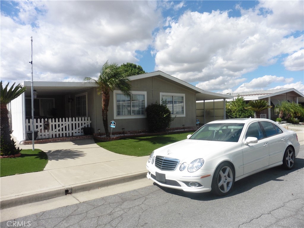 CONTINGENT ON SELLER FINDING A SUITABLE REPLACEMENT HOME. Say NO to paying space rent and you own the LAND in the Sierra Dawn North 55+ Senior Living. This single story manufacture home is on a permanent foundation and qualifies for all types of financing. Almost impossible to find a property in this community that also has a covered carport and attached garage with direct access. You will not struggle finding a place to park and their is Ample amount of space to park multiple vehicles in the garage, carport or the driveway. Low maintenance and water saving landscaping that will help save you money. White picket vinyl fencing, and large covered porch area. Oversize family room that has plenty of space for bigger size furniture, separate dining area with ceiling fan, Kitchen with lots of cabinets, pantry, formica counters that is adjacent to the enclosed patio that could be used as a craft room. This two bedroom, two full bathroom with it's own laundry room that has additional cabinets and a sink gives you approximately 1464 of living area. Affordable extremely low YEARLY HOA of $40. Close proximity to Target, Home Depot, grocery stores, and restaurants. Act now and don't miss out on affordable living in Southern California. CONTINGENT ON SELLER FINDING A SUITABLE REPLACEMENT HOME.