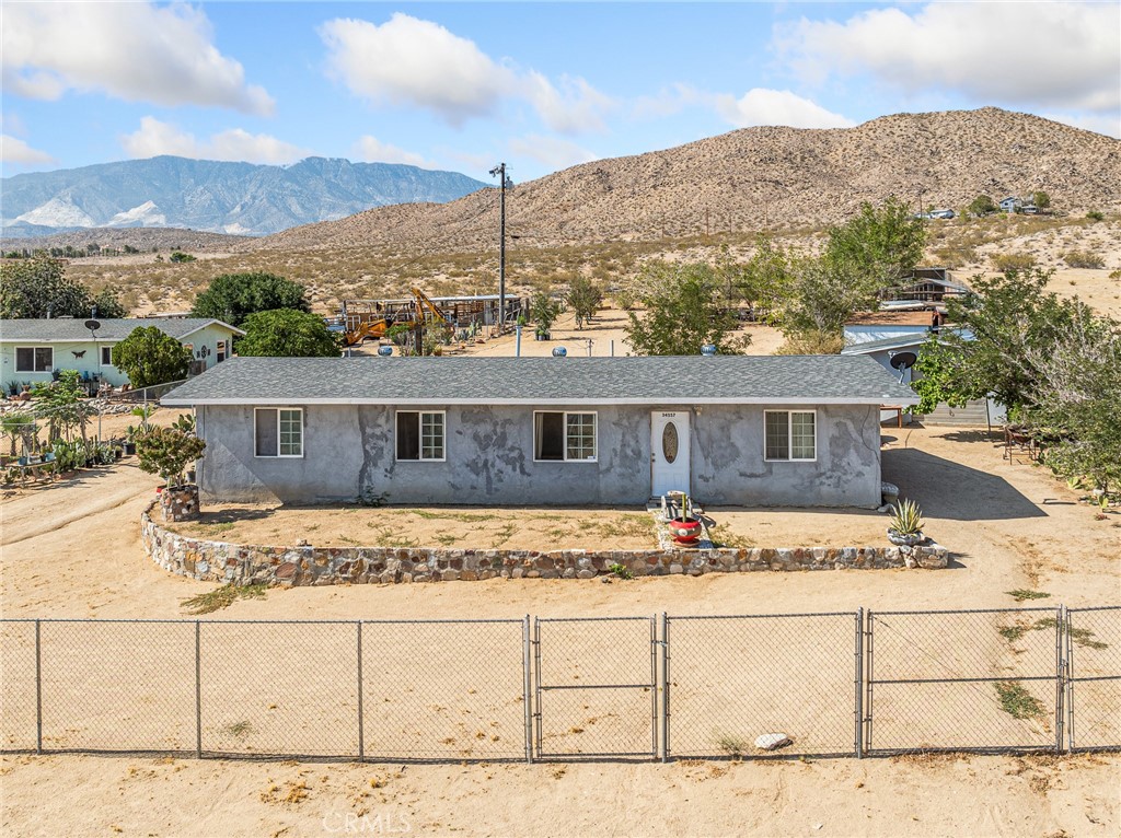Discover the potential in this 3-bedroom, 2-bathroom home nestled on a spacious 0.75-acre lot with breathtaking views of the surrounding desert and mountains. Located just a short 20-minute drive to Big Bear, this property offers the perfect balance of rural tranquility and easy access to outdoor recreation. Inside, you'll find tile flooring throughout for easy maintenance and a cool, clean aesthetic. The open living space connects to a functional kitchen, ready for your personal touch. The home could use a little TLC, but with some updates, it has all the makings of a fantastic home. Step outside and enjoy the expansive backyard, featuring dedicated animal pens, perfect for hobby farming or 4-H projects, and a shaded outdoor sitting/BBQ area ideal for entertaining or relaxing while taking in the stunning desert sunsets. With plenty of space, natural beauty, and tons of potential, this property is a must-see for those seeking peace, privacy, and the charm of high desert living. (This is a cash sale only.)