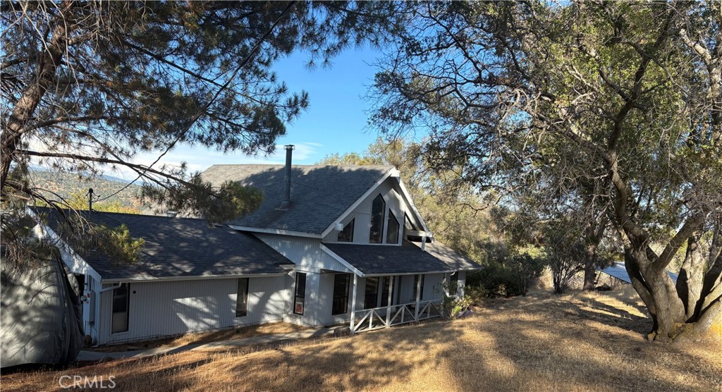 Chalet-Style Home with Sierra Views. 1,767 sq ft 3 bed, 2 bath home on a private 1.15-acre lot with stunning views of the Sierras. Updated 5 years ago with custom kitchen cabinets, granite countertops, stainless steel appliances, new carpet, and fresh paint inside and out. Vaulted beam ceilings with tongue-and-groove wood add rustic character, while the open loft provides extra space for an office or bonus room. Spacious bedrooms all feature walk-in closets. Both bathrooms have been tastefully remodeled. Cozy up to the beautiful wood-burning stove or enjoy the outdoors on the large covered back patio or covered front porch. Mature trees, natural rock outcroppings, and concrete walkways create a serene outdoor setting. Additional features include a newer HVAC system, leased Sun Run solar panels, and ADT security system. Plenty of room to relax, entertain, and enjoy mountain living just 35 minutes from Riverpark. A rare blend of comfort, character, and convenience—ready for you to move in!