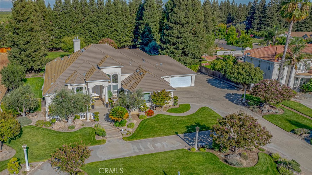 5 Car Garage, High Ceilings, 8’ Tall Doors, and Low E Windows, are just a few of the many amazing features of this welcoming 4-bedroom, 3-full-bath home offering 3,784 sq ft of elegant living space on a beautifully landscaped 1-acre lot. The front and backyard were professionally landscaped by a top notch landscape Company out of Fresno, You’ll see the quality when you drive up to the residence. It sets the tone as you walk thru the double door entry boasting a Travertine tile entryway into a spacious living room offering an open floorplan with high ceilings and picture windows that frame the breathtaking backyard. The yard is beautifully landscaped and has a stunning inground pool with a rock waterfall and spa. The chef’s kitchen features white cabinets, granite countertops, stainless steel appliances, double ovens, built-in refrigerator, two sinks, walk-in pantry, and a breakfast bar—perfect for entertaining. The spacious primary bedroom boasts marble floors, a huge master closet, dual vanities, and a luxurious jacuzzi bath. A versatile flex room/den can serve as a 4th bedroom, game room, or gym. It would also make a very nice In-Law quarters. There’s loads of cabinet and storage space and a very nice laundry room. Enjoy custom speakers throughout the home for an immersive audio experience. The backyard is a true oasis with a waterfall, a gas fire pit with a stone sitting area, and stamped concrete. 2 HVAC units, and 2 Water Heaters. Experience country living close to all amenities.