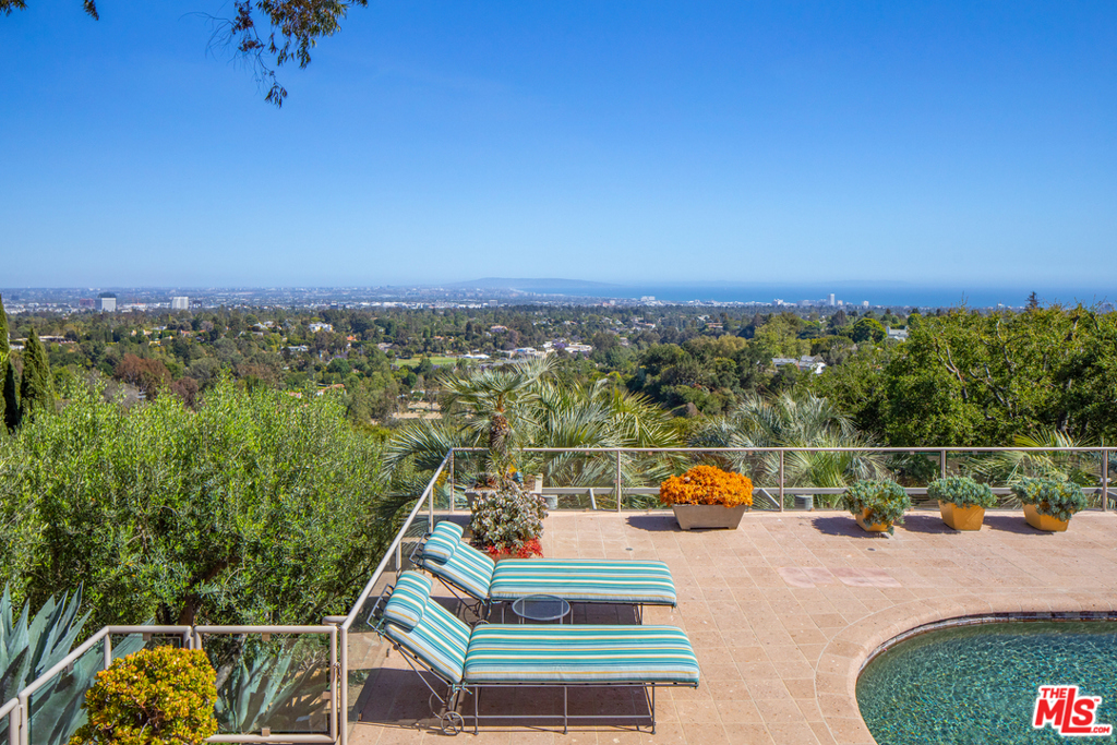 On a secluded 2.2+ acre knoll, with breathtaking views from downtown L.A. to the Pacific Ocean, this dazzling TWO RESIDENCE (two parcels) compound designed and later renovated by renowned architect, Richard Martin AIA, is a seamless blend of cutting-edge contemporary style, warmth, comfort and wrapped in an elegant traditional sensibility. Here is a unique and private world of uncommon quality and incomparable beauty.The MAIN HOUSE of approximately 7,500+ square feet encompasses 5 en-suite bedrooms, including a stunning primary bedroom with dual baths and walk-in closets, private view-oriented office, dramatic center island kitchen/family room, wine room, lower level screening room, game room and secure safe room/bomb shelter. In addition, there is a separate professional gymnasium building with bath and private access. Bleached, wide plank hardwood floors, vaulted sky-lit ceilings, 3 fireplaces and two lavish outdoor patios blend harmoniously to create a rare and inviting lifestyle.Completely hidden from the main residence, and protected by a proscenium of lush garden landscape is a SECOND RESIDENCE (Guest House) of approximately 4,900+ square feet, also exquisitely renovated and updated by the current owner with the architect. This luxurious residence has 3 generous bedrooms, 4 baths, double powder rooms, an elegant library/office, kitchen/family room, stunning formal dining room, 4 fireplaces and a completely private guest apartment with living room, bedroom, bath and kitchen -- all punctuated with hardwood floors, high ceilings, French doors throughout and city, ocean and mountain views. And the grounds ... reminiscent of the gardens of Tuscany and Provence, uniquely designed by landscape architect Nancy Goslee Power -- a profusion of color, specimen olive, palm and stately oaks, rolling lawns, gentle water elements, towering cypress, swimmers pool and carefully sculpted stone romantic pathways. Double large motor courts and covered parking for six cars complete this exceptional estate.There are very few properties dotting the Southern California landscape of greater allure and magic as this unique Brentwood compound. Truly a rare and remarkable offering.