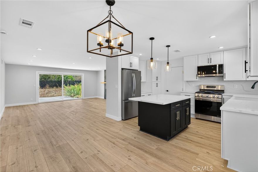 Welcome to this beautifully reimagined residence, perfectly situated on a tranquil tree lined street framed by blooming Jacaranda trees each spring. Thoughtfully renovated with a focus on quality craftsmanship and timeless design, this home offers an elevated living experience that blends modern comfort with refined sophistication.



From the moment you step inside, you are greeted by smooth finished walls, elegant ceilings, and premium vinyl plank flooring that flows seamlessly throughout. Every interior door, entry door, and closet door has been replaced, creating a cohesive and polished aesthetic. A custom built hallway vanity with upper and lower cabinetry and a sleek quartz countertop provides stylish and functional storage while enhancing the home’s upscale appeal.



The fully renovated bathroom serves as a serene retreat, featuring a custom vanity, designer tile work, a new soaking tub, and contemporary lighting that evokes a spa like atmosphere. The kitchen is both beautiful and functional, showcasing shaker style soft close cabinetry, quartz countertops, and an oversized island with seating, ideal for both intimate meals and large gatherings. The open floor plan extends into the bright and inviting family room, complete with a cozy fireplace and sliding glass doors that lead to the backyard, creating a seamless indoor outdoor living experience.



The expansive, level backyard offers endless potential, whether you envision building an ADU, designing a resort style pool, or creating a private garden oasis. Additional highlights include a dedicated laundry room, a spacious two car garage, and a versatile backyard shed that can serve as extra storage or a creative workspace.



With sophisticated updates, exceptional attention to detail, and a highly desirable location, this home stands out as a rare opportunity to enjoy elevated living in a peaceful, picturesque setting. It is a truly move in ready property that combines luxury, comfort, and future potential in one beautiful package.