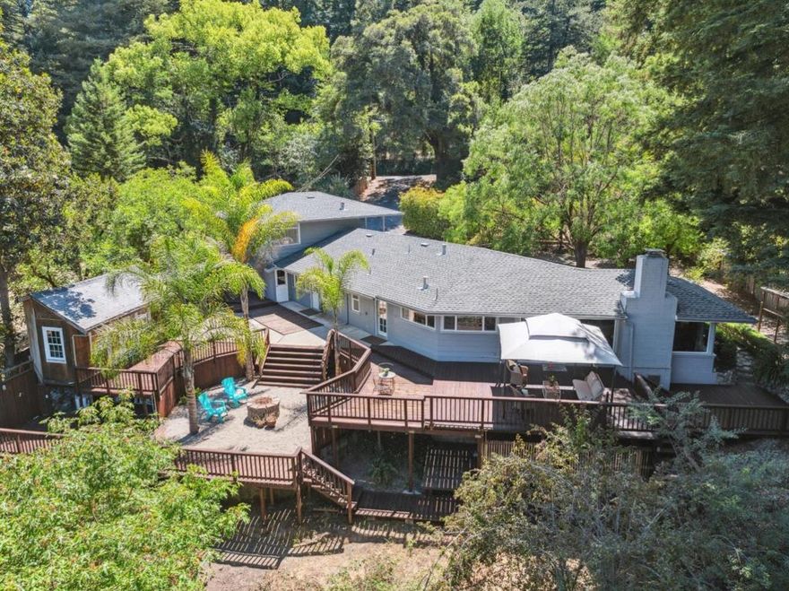 Located near some of the regions most stunning natural destinationsincluding Henry Cowell Redwoods State Park, Quail Hollow Ranch, and local beaches, this inviting property offers a peaceful space with tons of convenience. Set beneath a beautiful redwood canopy, the home features a spacious, open-concept layout that connects the living, dining, and kitchen areas, perfect for gatherings or relaxation. The single-level floor plan includes a well-equipped kitchen with dual ovens, generous counter space, and picturesque views of the surrounding landscape. Large windows bring in natural light, creating a bright and welcoming interior atmosphere. Venture outside to a spacious deck where you can enjoy the sounds of nature and take in the tranquil forest setting. Additional amenities include multiple outbuildings ideal for flexible use, a detached unit above the garage offering additional living or workspace, and ample parking. Whether youre looking to entertain, unwind, or explore the great outdoors, this property delivers versatility and comfort in a scenic, accessible location.