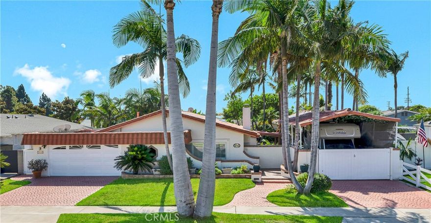 Absolutely unique and highly upgraded Spanish-style single story home on an interior cul-de-sac street just 4 miles from the beach and walking distance to neighborhood park with tennis, featuring 3 bedrooms, 2 baths, 1,509 square feet, finished garage, and an incredible 40-foot covered RV parking area with gated access—ideal for RV, boat, OR build an ADU - Home Comes with CITY APPROVED BLUEPRINTS for ADU. This home is an entertainer’s dream, inside and out, showcasing a stunning tropical oasis backyard with sparkling pool and spa set into natural boulders, waterfalls, river feature connecting spa to pool, lava fire pit, extensive outdoor lighting, two covered patios, a wrap-around wet bar, built-in Lynx BBQ center with river rock surround, stamped concrete and paver decking, and lush mature landscaping with palm trees and block wall fencing. Step inside this remarkable home through a solid wood & beveled glass entry door that opens to a tiled foyer and an elegant formal living room with cathedral open-beam ceiling, custom fireplace, décor niches, and French doors leading to the backyard. The spacious family room boasts hardwood plank flooring and custom oak built-ins with glass display cabinets, wine storage, wine cooler, and buffet counter, flowing seamlessly to the remodeled kitchen with granite countertops, stainless steel appliances, tile backsplash, breakfast bar, pantry, and a frameless bay window overlooking the resort-style yard. The luxurious primary suite offers French doors to the spa, a large walk-in closet with custom organizers, and a spa-like bath with skylight, huge steam shower with seating, vanity area, and heated toilet. The guest bath features glass block accents and an oversized jetted soaking tub, and skylight. Additional amenities include dual pane windows, plantation shutters, arched passages, recessed lighting, central A/C, and a finished garage with epoxy flooring, built-in storage cabinets, pull-down ladder to attic storage, and washer/dryer hookups. A one-of-a-kind property blending comfort, function, and resort living in one of the area’s most desirable neighborhoods with award-winning schools.