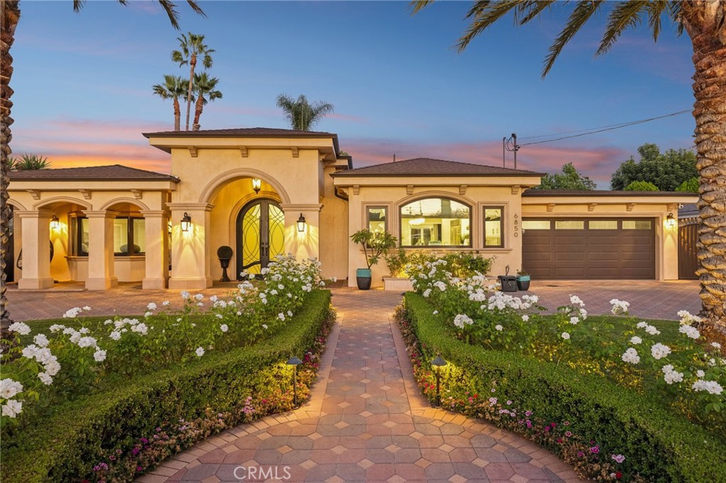 Welcome to 6850 Longridge Ave, a tastefully reimagined Mediterranean style villa featuring 3,450 sqft of living space designed with a light-filled, open floor plan ideal for large gatherings situated on an expansive 11,600 sqft lot! Upon entry you are greeted with an abundance of natural light, high ceilings, recessed lighting, and rich hardwood flooring seamlessly connecting the living room, kitchen, and family rooms. The chef’s kitchen boasts an extended center island w/ additional seating, high-end stainless appliances, wine cooler, and plenty of cabinetry. The spacious primary bedroom features a spa-like en-suite bath and roomy walk-in closet with custom built-ins. A secondary bedroom also features an en-suite bath and the third bedroom is paired with a private bonus room. Both the interior & exterior of the home are wired with a high-end audio system catering to audiophiles for the ultimate listening experience. For those who love spending time outdoors, a resort-style backyard paradise awaits. Surrounded by palm trees, the covered patio & BBQ area overlooking the glistening pool, spa & firepit makes this an ideal, private setting for gatherings day or night. Additional highlights include a spacious garage w/ ample storage space to accommodate any buyers’ needs while the circular driveway can support parking for large families. Don’t miss this one-of-a-kind home blending sophistication, comfort, and unforgettable entertaining spaces.