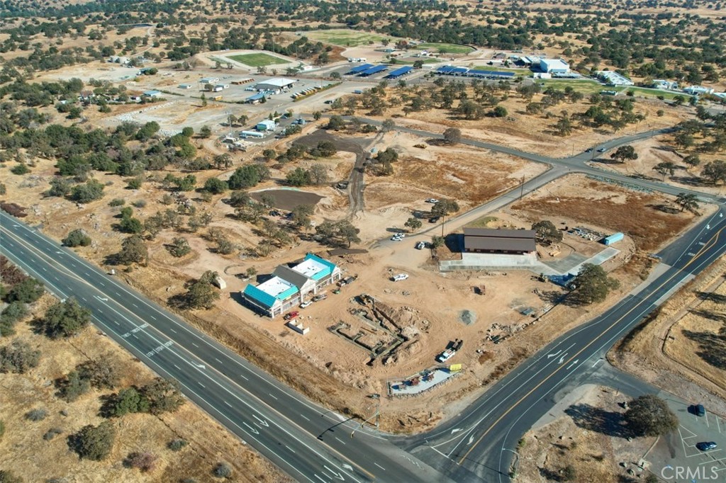 This gently sloping .48+/- acre corner parcel with ample (300’+/-) road frontage along the south & west sides of the parcel is ideal for a drive thru, car wash or office building. Purchase parcels 8 & 9 & own the NW corner of Wisteria Way & Sunflower Lane. This parcel is located near the main entrance to the project. This convenient location is ideal to serve the needs of residents, the Minarets High School students & their parents, the high school faculty & employees, commuters from Bass Lake, Coarsegold, Fish Camp, Oakhurst, & North Fork traveling to Fresno & Madera as well as all tourist travelers traveling to or from Yosemite National Park via the Highway 41, the “south entrance” to Yosemite. The property is Zoned “Planned Development District” (PDD). The General Plan is “Community Commercial.” An Urban Market/Chevron Gas station, real estate office, dog grooming, & a food court are currently under construction in this development. The Owners Association of the project will pay for maintenance of the common area improvements including private roads, maintenance of water & sewer lines & lift station operation & repair, landscape maintenance & irrigation, & street lighting. This new shopping center development accessed by a “Caltrans traffic light” controlled intersection.