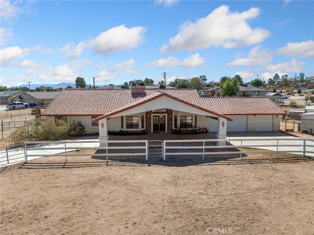 Welcome to this well maintained traditional ranch style home situated on a spacious 1.16 acre corner lot in the highly desirable neighborhood of Desert Knolls. Offering 4 bedrooms and 2.5 bathrooms, this home combines comfort, functionality, and added equestrian amenities in one exceptional package. Step inside the formal foyer and through the arches to the formal living and dining rooms. Perfect for gatherings, the formal living room features a brick accented fireplace with raised hearth and mantel, while the formal dining room provides an elegant setting for entertaining and hosting those special events throughout the year. The Island Kitchen is a chef's delight with abundant cabinetry, a walk-in pantry, an eating area and a generous breakfast bar overlooking and open to the spacious family room. Family room offers a warm setting inspired by another brick accented fireplace with raised hearth and mantel as well as high ceilings, natural lighting from the many windows and glass door that leads to the outside patio area with an intimate spa for relaxation. The primary suite is a private retreat with a sun-filled sitting area, French doors to the outside and a large walk-in closet. The primary bath offers dual sinks, soaking tub and separate shower. Three additional bedrooms are generously sized with mirrored wardrobes. Equestrian lovers will appreciate the improved horse facilities including three corrals with shelters, a hay barn, large turnout with shelter and a moderate arena. The property also features two outbuildings for additional feed and storage. A rounded driveway with drive through portico adds both charm and convenience. Modern upgrades include a nearly new, PAID FOR SOLAR SYSTEM, providing ample energy for a large household and a WiFi security system with cameras and alarm for peace of mind. This property offers the perfect blend of rural living with modern amenities. Don't miss the opportunity to call this exceptional property your new home.