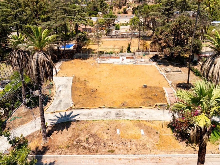 Nestled at the end of a serene private cul de sac in Altadena, this remarkable south facing parcel spans approximately 23,250 sq ft  and has gorgeous mountain views. The once standing 3,099 sqft residence was tragically lost to the devastating Eaton Fire, yet the property emerges today as a rare blank canvas with a fully intact in ground pool and a circular driveway that invites visionary redesign. Situated among some homes that endured the blaze, the lot benefits from a resilient community context and enhanced privacy. This is a turnkey opportunity for a discerning buyer seeking to build a custom retreat, whether modern, sustainable, or architectural in expression- where sun drenched exposure, beautiful views, and a standing pool converge on an expansive, cleared site ready for your dream home. Owner holds partial interest of the private street.  Don't miss out on this beautiful wide lot! Drive by only. Do not walk the site. All those who chose to walk on the lot will be at their own risk. The lot contains debris and potential hazardous materials.