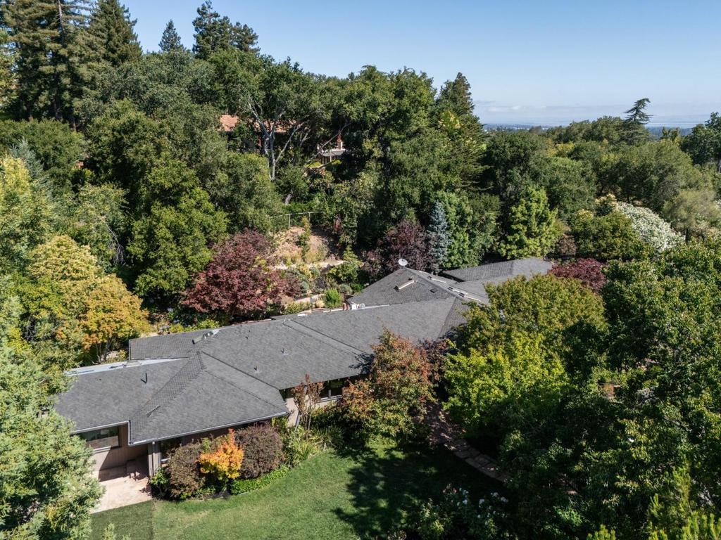 Showcasing original craftsmanship of mid-century modern design, this 4-bedroom, 2.5-bath home features just completed updates that exude luxurious living for today. Refinished hardwood floors in a matte finish now extend throughout, main living area ceilings are paneled in rare heart redwood, and there is a dramatic use of glass and skylights highlighting original details thoughtfully updated with modern style. Most rooms open to a brick terrace and the gardens with vast stretch of lawn, bountiful rose gardens, and mature Japanese maples that line a walkway to the secluded pool and spa. Spanning almost one acre, this property is close to the open space of Rancho San Antonio Preserve, which offers added privacy, as well as convenient access to its many trails. With a close-in location, a new roof, bonus room in the garage perfect for an office, and access to top-rated Los Altos schools, this is a very special place to call home.