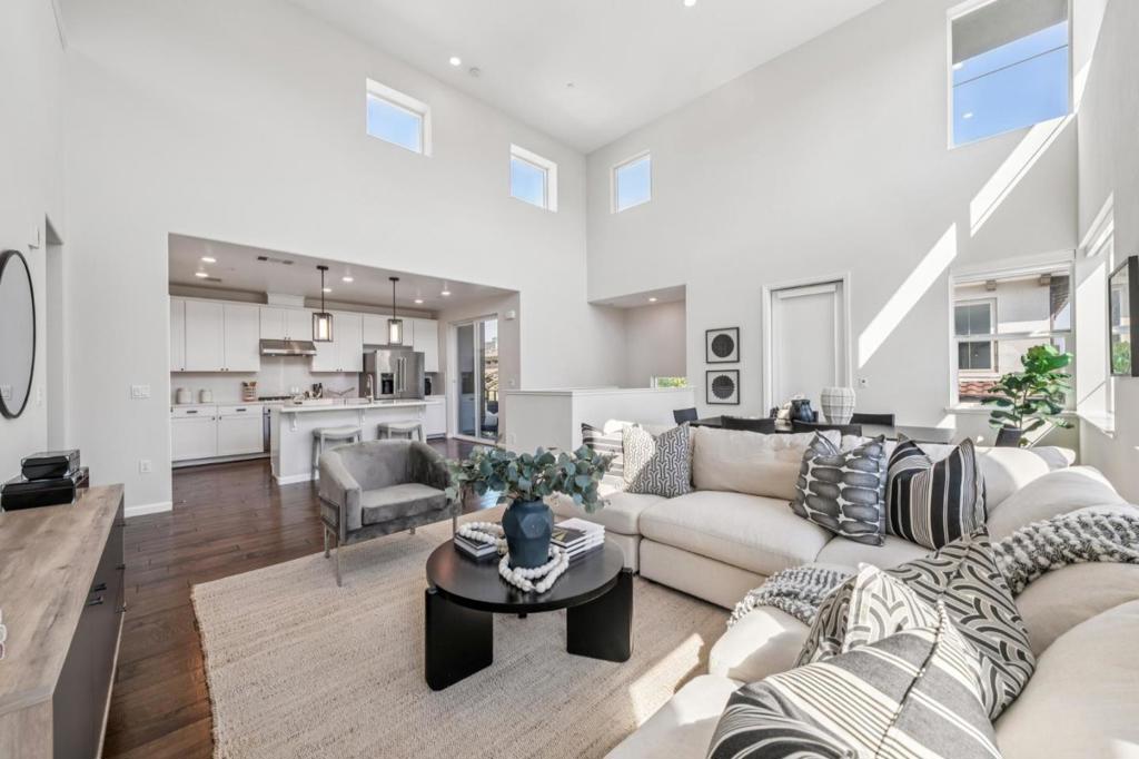 Welcome to this stunning end-unit on a premium lot with soaring ceilings, views and an open-concept layout. This 2BD/2BA + spacious loft home showcases $90K+ in upgrades. The gourmet kitchen features custom-painted cabinets, a chefs island with statement pendant lighting, Caesarstone countertops, full backsplash, KitchenAid stainless steel appliances and a pantry with an outlet for a microwave or coffee station. The main level flows seamlessly from the kitchen to dining and living areas, opening to two decks perfect for morning coffee, evening wine or al fresco dining. Both bedrooms are on this level, along with two beautifully upgraded baths offering shaker cabinetry, double sinks in the primary, quality finishes and an enclosed shower in the second bath. In-unit LG washer/dryer is located between bedrooms. Storage abounds with three built-in closets, including the primary suite's large walk-in. Upstairs, the loft is ideal for an office, gym, media room or guest retreat. Additional highlights include engineered hardwood floors, premium carpet on stairs, remote-controlled blinds, water softener, Nest, tankless water heater, EV charger, stainless steel handrails and recessed lighting. Prime location just steps to William Manly Park, close to Hwys 87, 280 & 101 and major tech hubs.