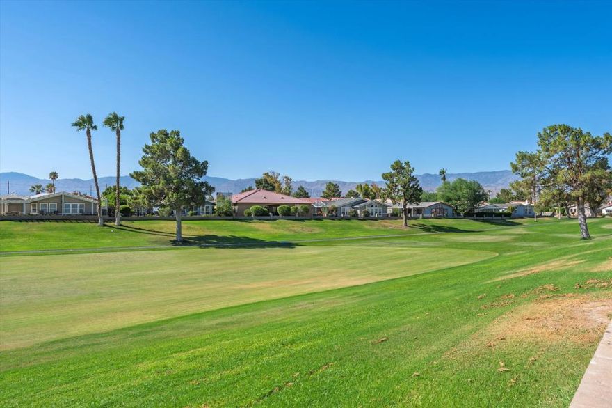 One of the Best Values in Tri-Palm Estates. Welcome to this beautifully maintained 3-bedroom, 2-bath single-family home offering an exceptional location on the golf course. With unobstructed southern views of the fairway and surrounding mountains, this residence delivers both serenity and style. The open and light-filled floor plan features a vaulted living room ceiling, updated flooring, and expansive windows framing the scenic outdoors. The kitchen is well-appointed with tile counters, upgraded stainless-steel appliances, and modern fixtures. Additional highlights include ceiling fans throughout, custom window coverings, and sun screens for energy efficiency. Outdoors, enjoy a wrap-around patio with covered areas, perfect for relaxing in sun or shade. The elevated garden offers lush citrus trees and space for herbs or vegetables--an ideal setting for those who enjoy gardening. The home also provides a two-car garage plus a golf cart garage. Tri-Palm Estates is a sought-after 55+ community offering remarkable value with free golf for 2 owners on title, clubhouse, restaurant, 2 community pools/spas, tennis and pickleball, shuffleboard. Just minutes from great shopping, dining, Costco, Acrisure Arena, casinos, entertainment venues, this property blends leisure, convenience, and lifestyle.