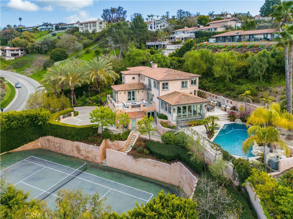Luxury, elegance, and privacy await you in this exquisite 5 bed, 5.5 bath, 6,280 Sq Ft ocean view estate located in the prime neighborhood of Montemalaga in the heart of Palos Verdes Estates. Crafted in 2005 by Architect Edward Carson Beall, this “transitional” home boasts premium construction and an elevated level of architectural detailing that spared no expense. Nestled at the top of a grand, gated driveway and surrounded by lush landscaping for added privacy, this house exudes luxury. Enjoy the resort-worthy features throughout the property, encompassing a full sized tennis court, attached 3-car garage, temperature-controlled 2,000+ bottle wine cellar, pool and spa. The home’s most recent upgrades offer a timeless and modernized feel, while preserving its original craftsmanship, including a newly painted interior, refinished hardwood flooring, and updated light fixtures throughout.The main entrance welcomes you in with abundant natural light, high ceilings, custom moldings, limestone, and hardwood floors. Sophistication meets relaxation with its formal living room, office, gourmet kitchen equipped with high-end appliances, and separate formal dining room that leads out to a cozy outdoor living area with picturesque views. The family room is ideal for entertaining, with a hidden projector screen, full wet bar, and elegant French doors that open out to the pool, spa, tennis court, outdoor dining area, barbecue, fireplace, and Queen’s Necklace view. In addition, several charming fountains adorn the property creating an atmosphere of tranquility and serenity. Wake up to exquisite views of Malibu and the South Bay in the primary suite which includes a huge walk-in closet, dual-vanity sinks, and spa-like bathtub. With 3 more bedrooms plus an additional guest en-suite independently located on the bottom floor, this home truly has it all. This private estate is just a few short minutes from top-rated schools, shopping, restaurants, and all other amenities that embody a Palos Verdes lifestyle. Come discover the perfect balance of luxury and convenience today!