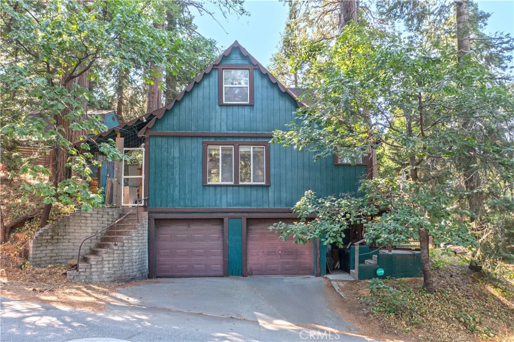 Nestled on a quiet street in Crestline Village, 23940 Cresta Drive is a beautifully updated two-level mountain cabin offering approximately 910 ft of living space on a serene 7,700sq of forested lot. Featuring 3 bedrooms and 1.2 baths, the interior is richly appointed with tongue-and-groove knotty-pine walls and vaulted ceilings, while a huge steel fireplace efficiently heats the entire home. Recent upgrades include a brand-new composition roof and a whole-house standby generator, ensuring durability and uninterrupted power, perfect for mountain living. Additional highlights include a two-car attached garage, a level backyard, and a redwood deck wrapping around a majestic mature tree. A detached, sound-proof studio or office equipped with electricity, gas heat, and AC provides a versatile workspace or creative use. Located less than a mile from Lake Gregory, the property offers convenient access to water recreation, hiking trails, and village amenities, all nestled within the natural beauty of the San Bernardino National Forest.