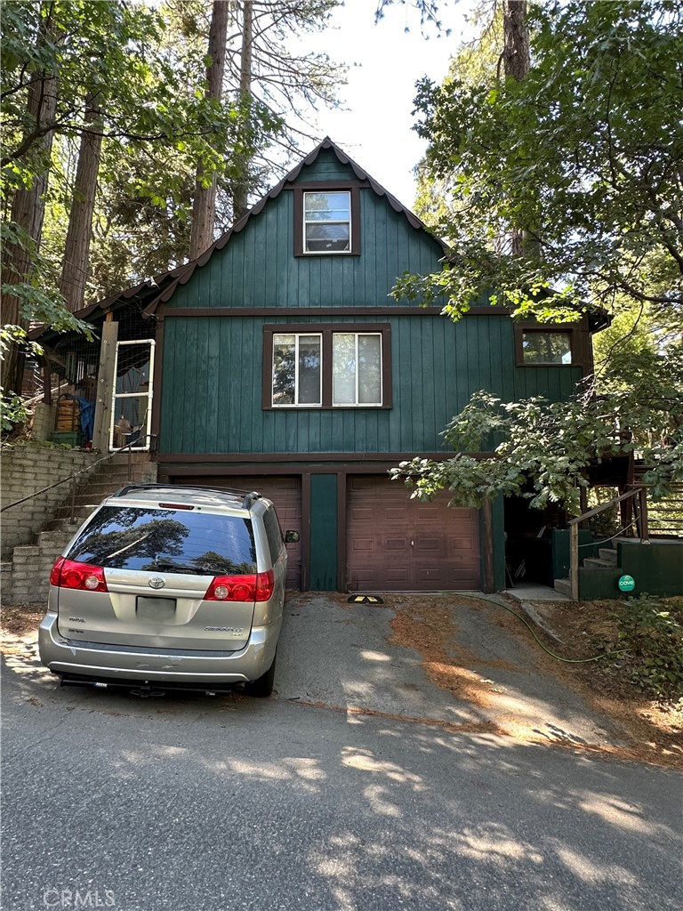 Nestled on a quiet street in Crestline Village, 23940 Cresta Drive is a beautifully updated two-level mountain cabin offering approximately 910 ft of living space on a serene 7,700sq of forested lot. Featuring 3 bedrooms and 1.2 baths, the interior is richly appointed with tongue-and-groove knotty-pine walls and vaulted ceilings, while a huge steel fireplace efficiently heats the entire home. Recent upgrades include a brand-new composition roof and a whole-house standby generator, ensuring durability and uninterrupted power, perfect for mountain living. Additional highlights include a two-car attached garage, a level backyard, and a redwood deck wrapping around a majestic mature tree. A detached, sound-proof studio or office equipped with electricity, gas heat, and AC provides a versatile workspace or creative use. Located less than a mile from Lake Gregory, the property offers convenient access to water recreation, hiking trails, and village amenities, all nestled within the natural beauty of the San Bernardino National Forest.