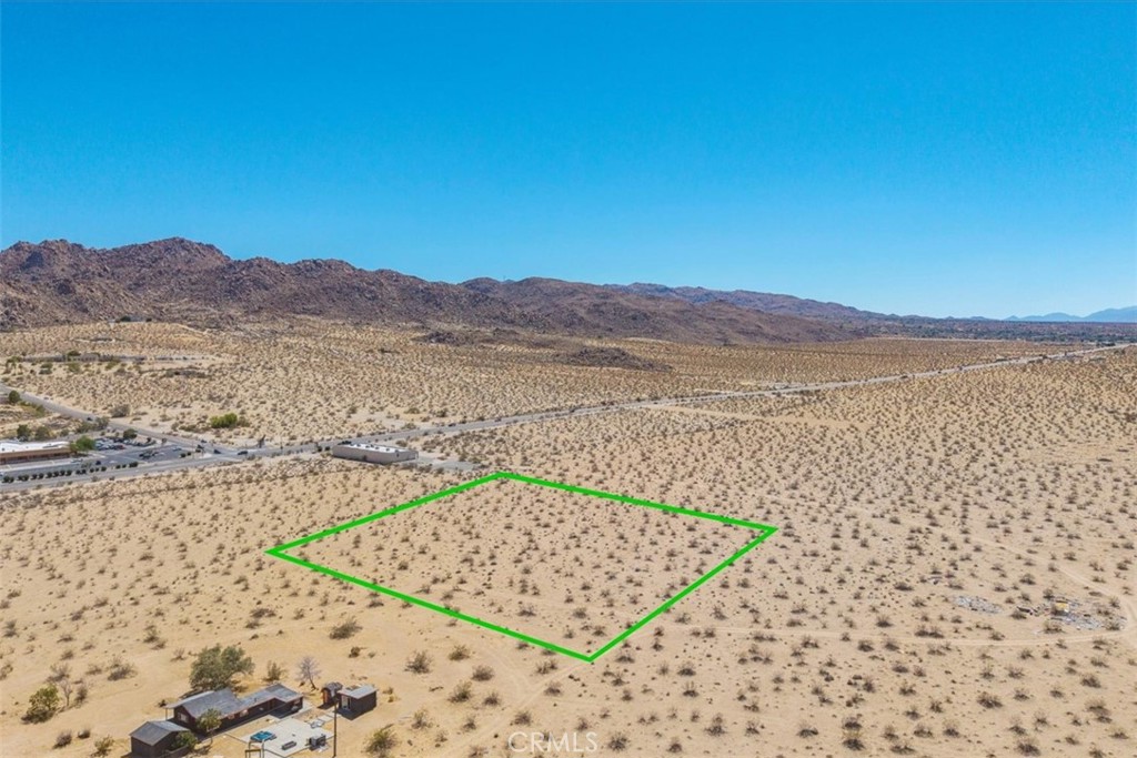 This parcel of land in Joshua Tree offers a wide-open canvas with expansive views stretching across the desert basin toward the rugged ridgelines of Joshua Tree National Park. The lot is flat and ready for future plans, whether that means building a primary residence, creating a private retreat, or developing a weekend escape. Electricity is close by, and a water meter may be available through Joshua Basin Water District (buyer to verify).
The location places you minutes from the National Park’s west entrance, a world-class destination for hiking, climbing, and stargazing. Downtown Joshua Tree is also within easy reach, where the weekly farmers market, art galleries, and local music events bring the community together. With its balance of quiet seclusion and access to area highlights, this property provides an opportunity to shape your own desert lifestyle.