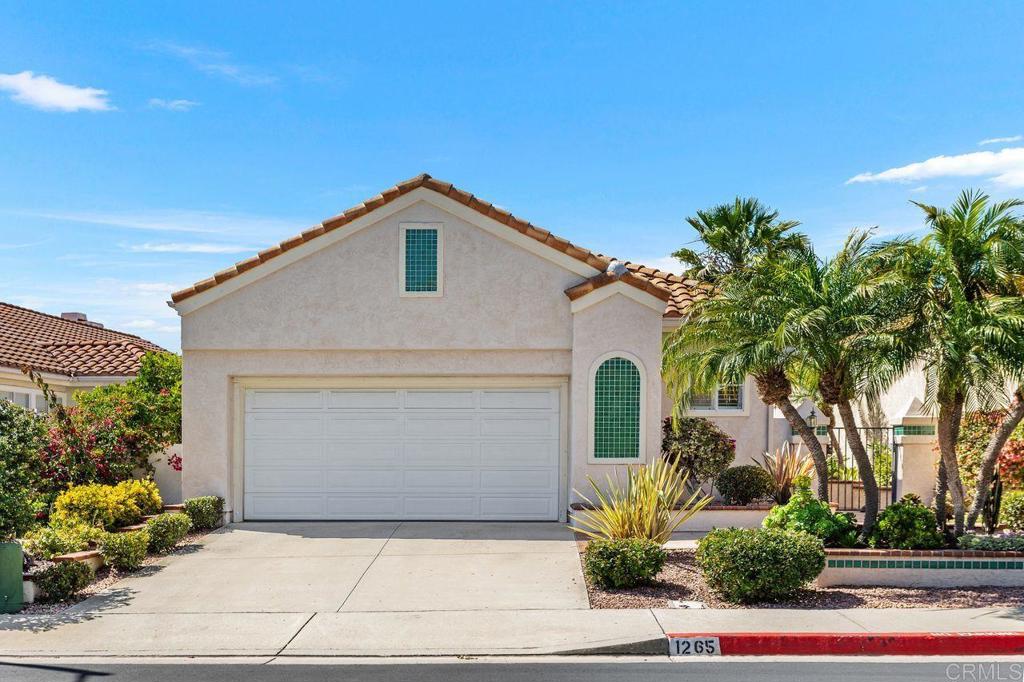 Welcome to The Fairways at Lake San Marcos — one of North County’s most cherished communities, where panoramic views, coastal breezes, and refined living create the perfect setting for a relaxed yet elegant lifestyle. Built in 1992 and thoughtfully maintained, this single-level residence sits on a gentle rise in an exclusive, guard-patrolled neighborhood. Tucked away from Rancho Santa Fe Road, the home offers peace, privacy, and a prime vantage point to enjoy its breathtaking surroundings. Inside, vaulted ceilings, expansive windows, and natural light highlight the open-concept design. The spacious living room with a cozy fireplace flows effortlessly into the dining area and kitchen—perfect for both daily comfort and entertaining. Stained-glass accents add artistic charm, while the seamless indoor-outdoor connection draws your attention to the sweeping views beyond. This desirable lot features unobstructed panoramas of lush green fairways, rolling hills, and the distant Pacific Ocean. At sunset, the sky transforms into a canvas of vibrant color—adding beauty and serenity to your everyday life. The vaulted ceiling primary bedroom offers both a walk-in closet and a sliding-door closet in the bathroom, each with built-in organizers. The en-suite bath features a soaking tub, separate shower, and new smart toilet.—creating a true private retreat. Additional highlights include an attached two-car garage with built-in cabinetry, a deep utility sink, and abundant storage. The Fairways community enhances the lifestyle with scenic walking paths, manicured green spaces, and a welcoming neighborhood feel. Residents enjoy a heated pool and spa, along with 24-hour security patrol. For a minimal fee, you may also join the Lake San Marcos amenities, including two more pools, a spa, tennis and pickleball courts, kayaking, fishing, and a vibrant lakefront clubhouse. Perfectly located, this home is minutes from fine dining, boutique shopping, sandy beaches, and endless recreational opportunities. Whether you’re searching for a full-time residence or a peaceful second home, this property combines comfort, elegance, and unforgettable views in one of San Diego’s most desirable hidden gems.