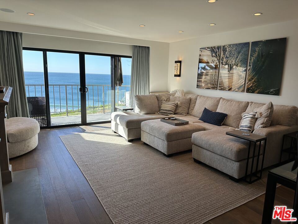Nestled in the highly sought-after Zuma Bay Villas, this stunning 2-bedroom, 2.5-bathroom townhouse offers a perfect blend of luxury and coastal living. Step into an open-concept layout featuring a beautifully updated kitchen and premium appliances. A cozy fireplace and rich hardwood floors set the tone throughout the home. Enjoy breathtaking ocean and whitewater views at this serene and private retreat from the living room and primary bedroom. Relax and entertain on the front patio or the expansive balcony off the living room, ideal for savoring Malibu's ocean breeze. Zuma Bay Villas residents enjoy lush landscaping, a heated saltwater pool, spa, tennis courts, and a clubhouse. Plus, direct access to iconic Zuma Beach from the bluff just steps away from the Sunset restaurant below.