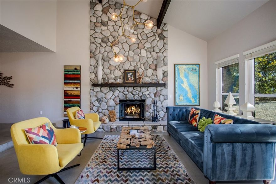 Welcome to The Lodge at Blackrock, a striking modern lodge-style residence designed by a renowned global interior designer. Located in the sought after Upper Sky Harbor on the last paved street at the top of the hill, this property is mere steps away from Joshua Tree National Park and hiking at Blackrock entrance, offering a rare blend of luxury, comfort, and iconic desert serenity.

Step inside to a grand two-story living room anchored by a massive stone wood-burning fireplace, with walls of glass framing panoramic desert and mountain views. The open floor plan flows into a formal dining area and a chef’s kitchen with premium finishes, ample counter space, and a cozy breakfast nook. A second living area with a pellet stove fireplace provides a warm and inviting retreat.

The home features 5 bedrooms (tax roll shows 4 beds - additional bed in converted dining room) and two-and-a-half baths, including a spacious primary suite with a luxury soaking tub and walk-in shower. Outdoors, relax in the 10-person “swim spa,” cool off in the cowboy tub, or gather around the fire pit under starlit desert skies. Located in a quiet neighborhood known for its natural beauty and peace, The Lodge at Blackrock offers a truly immersive desert lifestyle. Whether as a primary residence, vacation retreat, or investment property, this home checks all the boxes!