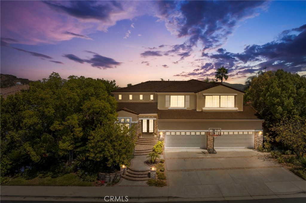 Live in the best of Summit Pointe, where sunsets, stillness, and sweeping canyon views set the tone. Behind gates, this private estate invites you into a lifestyle defined by connection, calm, and indoor-outdoor elegance. Inside, the home welcomes you with dramatic double-height ceilings, custom iron entry doors, and warm hardwood flooring throughout. The open layout flows seamlessly between formal and informal spaces: entertain in the living room, host gatherings in the dining area, or connect with loved ones in the kitchen. White shaker cabinetry, granite countertops, stainless steel appliances, and a central island create an inviting focal point. Custom folding doors open wide to blend the interior with the outdoor living experience. The adjacent areas on the first floor offer additional space to relax and unwind, while flexible bonus rooms support a variety of lifestyles, whether they are used as a media lounge, gym, workshop, office, playroom, or for a game of pool with friends. A guest suite with a private full bath, a powder room, a dedicated laundry area, and large garage parking spaces complete the main level. Outdoor living is effortless here. The expansive backyard was designed for enjoyment throughout the year, featuring a saltwater pool and spa, built-in BBQ, outdoor fireplace, and multiple lounge zones framed by mature trees and panoramic west-facing views for the best sunrises. A custom-designed irrigation system throughout a perfectly landscaped lawn with Southern California native plantings and an orchard adds both function and charm to the grounds. Upstairs, the primary suite is a serene retreat, complete with an enclave which could be used as an office, gym, or lounge, framed by French doors and mountain views, a dual-sided oversized closet, a newly renovated spa-style bathroom, and a private balcony ideal for quiet moments. Three additional bedrooms, each with its own ensuite bathroom, including one with a steam shower, offer privacy and comfort for everyone in the household. Thoughtful upgrades enhance the home’s ease of living: smart home automation, under-deck patio heaters, home theater surround sound, EV charging readiness, and a newer HVAC system. Located just minutes from scenic Topanga trails, Malibu’s coastline, and highly rated schools, this residence blends privacy, nature, and connection in a sought-after community. Come and see.