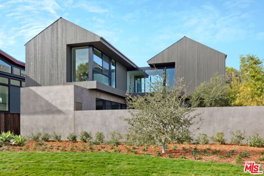 Located on one of the largest lots in Venice, this newly constructed home designed by award-winning architecture firm Marmol Radziner encourages indoor-outdoor living. Combining modern and rustic elements, the exterior materials of dark wood and plaster contrast with light-filled interiors of concrete, oak cabinets, and natural stone. The large open kitchen with a custom banquette dining table anchors the 1st floor, connecting the private front courtyard with fire pit and the spacious rear yard with pool and spa. The formal living room with fireplace and dining room are accented with a dark plaster wall while the casual family room is open to the kitchen, creating distinct zones for entertaining and everyday living. A guest suite opens onto the rear pool area. The 2nd floor features vaulted ceilings throughout, with three en-suite bedrooms, a large open den, and a glass bridge leading to a separate master suite wing with spacious spa-like bathroom. This private oasis is a must see!