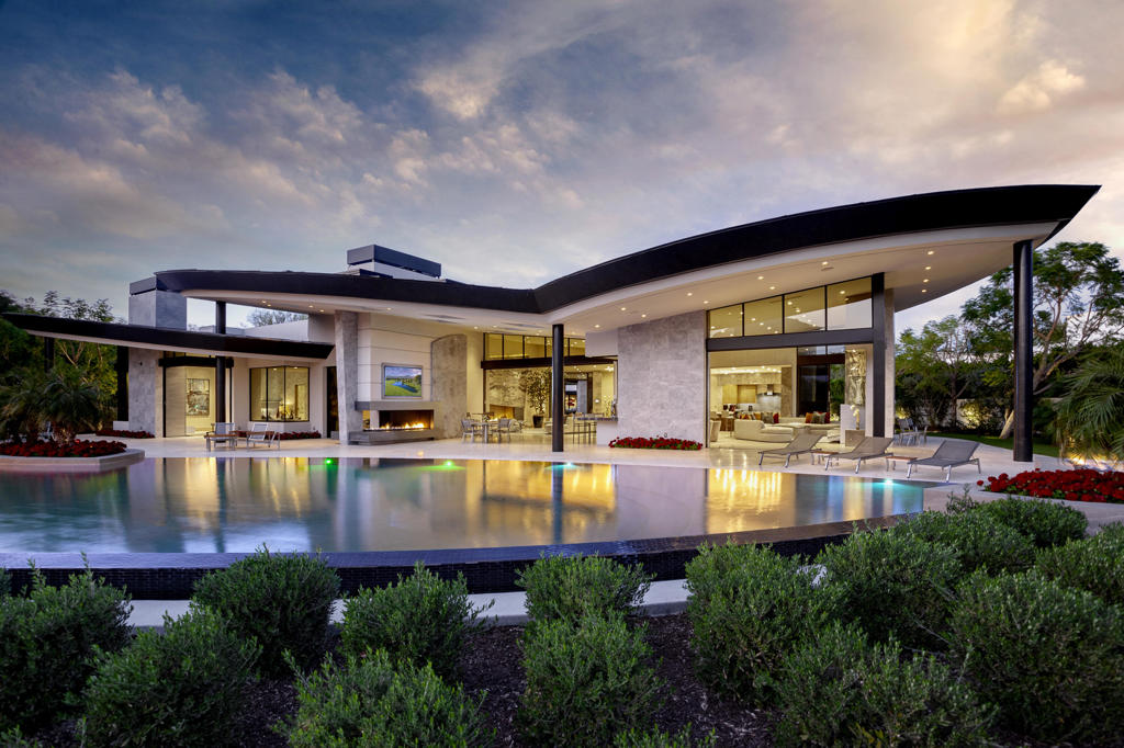 Privately gated estate on an acre and a half of impeccable grounds at the Madison Club! Six bedrooms, six baths and two powder rooms including a three bedroom guest house, plus office and media room. Approx. 9,974 sq. ft. of pure luxury... an architectural masterpiece with only the finest materials and meticulous craftsmanship. Features a circular drive with stunning entry hosting waterways, sculpture and outdoor reception area with fireplace and media. The expanse great room features custom fireplace and media, marble wet bar and formal dining room with glass display wine room and built-in buffet. The gourmet kitchen boasts a large island with breakfast bar, top of the line appliances, a catering kitchen and a morning room. Exquisite master suite with custom fireplace, media and living area. Guest accommodations include a three bedroom separate guest house with kitchen and outdoor living area. Walls open to extensive patio areas including outdoor living room with linear fireplace, media and an indoor / outdoor bar. Incredible infinity pool flanked by a wall of fire, BBQ area and an additional firepit. Beyond the property line is another acre and a half of HOA maintained open area for total privacy. Offered furnished per inventory!