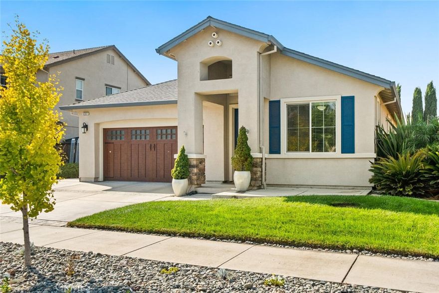 This newer North Chico home is move-in ready and offers great curb appeal with a custom wood-look garage door, a charming blue front door, and mature landscaping. The extra-wide driveway and side double-gates provide ample parking options, including potential for RV, smaller boat, or trailer storage. Inside, you'll find LVP plank flooring and an open floor plan that feels light and bright, thanks to high ceilings and numerous windows. The kitchen features an island, granite countertops, stainless steel appliances—including a new dishwasher and a 5-burner gas range with grill and dual ovens. A custom wall mural inspired by the Ahwahnee Hotel in Yosemite and warm wainscot paneling add a cozy, inviting touch. The home has four bedrooms: the primary and two others are adjacent, while the front bedroom with a built-in Murphy bed makes a versatile office or guest room with privacy. The backyard is truly delightful, offering a lush green lawn, covered patio with lighting and fan, a firepit area, accent lighting at night and two usable side yards. One side yard includes a vegetable garden with raised beds and a new Trex-style deck walkway, while the other provides concrete space perfect for an RV or kids’ play area. 16 solar panels installed in 2021 for low energy costs. This well-loved home is ready for its new owners—and it’s sure to be a place you'll love too!