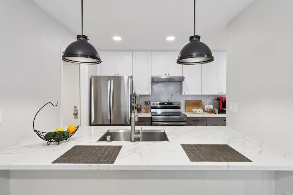 This beautifully updated La Costa condo showcases over $70,000 in top-quality materials and finishes, a functional open layout, and a prime location just 15 minutes from the coast. Situated next to the world-renowned La Costa Golf Course by Omni, you’ll enjoy amazing sunset walks and even fireworks views right from your neighborhood. Step inside to a light-filled living and dining area featuring luxury vinyl plank flooring and sliding doors that lead to a private balcony—perfect for enjoying your morning coffee or evening breeze. The remodeled kitchen is both elegant and practical, showcasing crisp white cabinetry, quartz countertops, stainless steel appliances, and pendant lighting over a spacious breakfast bar. Its seamless flow into the dining area makes hosting friends and family effortless. Bedrooms are generously sized with large windows and ample closet space, while the bathrooms feature stylish upgrades, including quartz vanities and modern fixtures. A conveniently located laundry room is just steps from your front door. New owners will also benefit from over $2 million in recent community upgrades, including an elevator to all floors, a sparkling pool, secure covered parking, and beautifully maintained common areas. The HOA fee covers water, and trash service, adding value and convenience to your everyday living. All of this is nestled in a sought-after neighborhood close to shopping, dining, golf, and the beach. Whether you’re looking for a primary residence, a vacation escape, or a smart investment, this home offers exceptional value and the relaxed coastal lifestyle La Costa is known for.