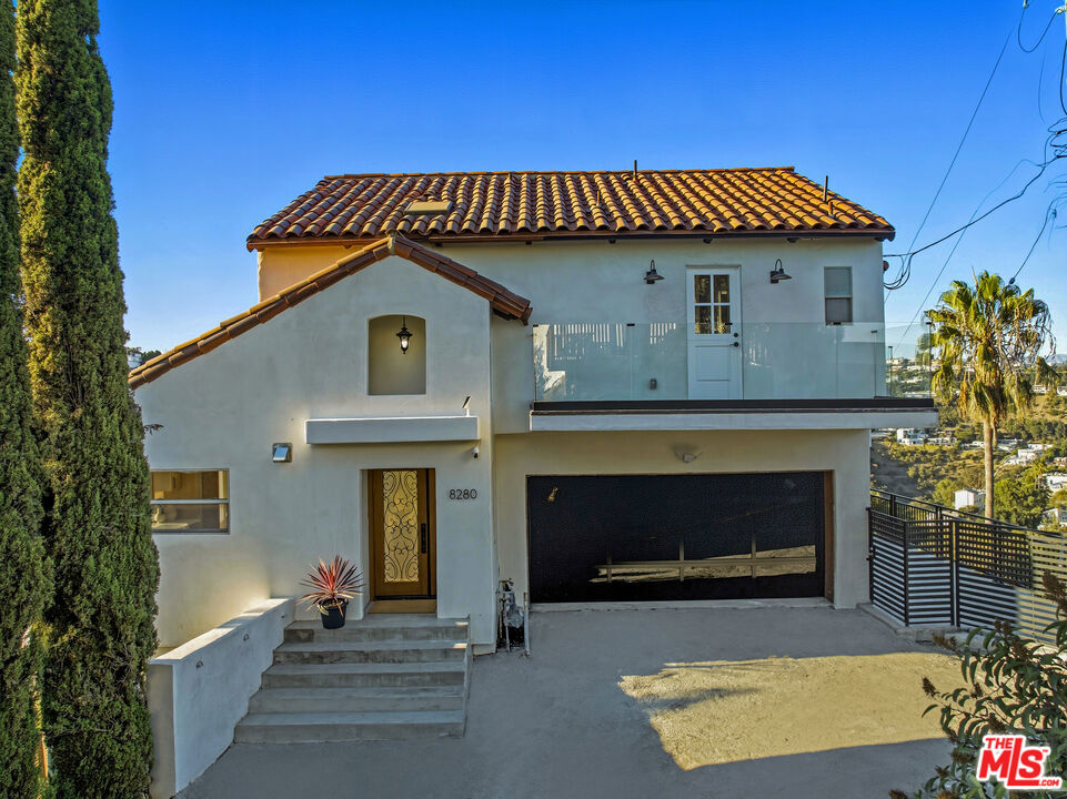 Stop the scroll and bathe in dramatic views in this Laurel Canyon luxe retreat! This newly reimagined Spanish 3-bedroom, 3.5-bath retreat offers 2,309 square feet of elevated living, blending timeless charm with modern sophistication. Arrive through a private gated drive and leave the world behind. Inside, the vaulted great room welcomes with airy proportions and natural light. The chef's kitchen is a true centerpiece, anchored by an expansive waterfall island perfect for gatherings. Custom white oak cabinetry, quartz counters, under-cabinet lighting, and brand-new stainless appliances make this space as functional as it is beautiful. The living room impresses with soaring ceilings and walls of glass, where French doors seamlessly dissolve indoor and outdoor boundaries. A sleek fireplace and warm oak accents create a setting equally suited for entertaining or quiet evenings at home. The entire third level is devoted to the primary suite, a private sanctuary above a crooning canyon. Floor-to-ceiling windows frame sweeping views, while a private balcony captures the glow of dawn. A vaulted wood-clad ceiling, fireplace, and spa-like bath with book-matched marble, dual vanities, glass-enclosed shower, freestanding tub, and freestanding sauna complete the retreat- you can literally bathe in the LA city skyline from the window in your primary shower! On the lower level, a versatile studio and dedicated screening room provide creative and practical flexibility, complemented by additional bedrooms and baths for family or guests. Multiple terraces and balconies extend the living space outdoors, connected by a striking spiral staircase. Whether for sunset cocktails or stargazing, each space offers a new perspective of the canyon and city skyline. Numerous thoughtful updates include engineered hardwood floors and custom tile floors, custom lighting, refreshed baths and high-end fixtures, dual staircases, remodeled powder room, central HVAC, upgraded energy, efficient windows and doors, and the added security of a privately gated entry shared with two neighboring homes. This refined yet welcoming residence is a turnkey showcase in one of Hollywood Hills West's most coveted enclaves. Just down the hill, the legendary spirit of Laurel Canyon awaits mornings at the Country Store, evenings at Pace, or the dining, shopping, and nightlife of nearby West Hollywood and the Sunset Strip. Privacy, space, serenity, and creativity await you! Welcome home!