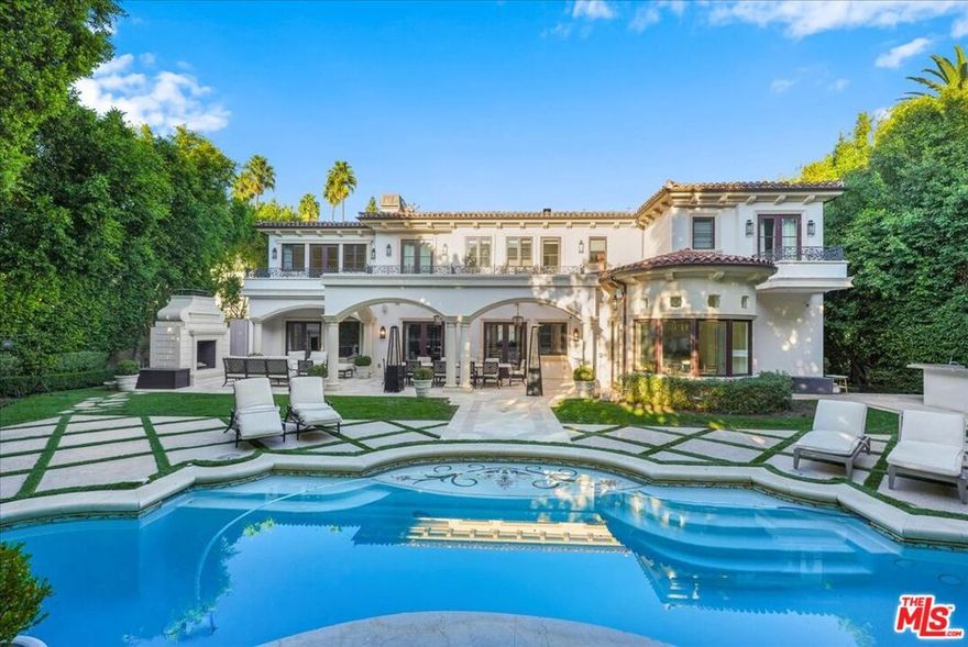 This timeless Beverly Hills estate embodies the perfect blend of modern sophistication, luxury, and family warmth, set on an expansive 22,418 sq ft lot in the heart of the prestigious Flats. Behind gated entrances and a grand half-moon driveway, you're greeted by manicured gardens and a striking two-story foyer with a dramatic dual staircase and crystal chandelier, a  breathtaking first impression.  Boasting 7 bedrooms, 10 bathrooms, and over 11,000 sq ft of exquisitely designed living space, the estate offers designer-done interiors featuring a marble-clad gourmet kitchen with top-of-the-line appliances, custom cabinetry, and a sunlit breakfast nook overlooking the backyard. The formal dining room, with its coffered ceilings, offers an elegant setting for hosting. The living room boasts bespoke built-ins, a grand fireplace, and seamless access to the outdoors, while an inviting family lounge combines comfort and style.  For leisure and wellness, this home offers a climate-controlled wine cellar, a state-of-the-art gym, and a luxury spa with a sauna and steam room. An immersive golf simulator room adds a unique touch of entertainment.  The primary suite is a sanctuary of tranquility, complete with dual spa-like bathrooms, expansive closets, and serene views of the gardens.  The resort-style backyard is an entertainer's dream, featuring a sparkling pool and jacuzzi, an elegant covered outdoor dining pavilion, and a cozy outdoor lounge with a grand fireplace perfect for both intimate family moments and grand-scale entertaining.With a 10+ car garage, this home caters to car enthusiasts while ensuring privacy and security. Located just moments from world-class dining, shopping, and top-rated schools, this estate isn't just a residence-it's a masterpiece of refined living, where timeless elegance meets modern comfort and family warmth.