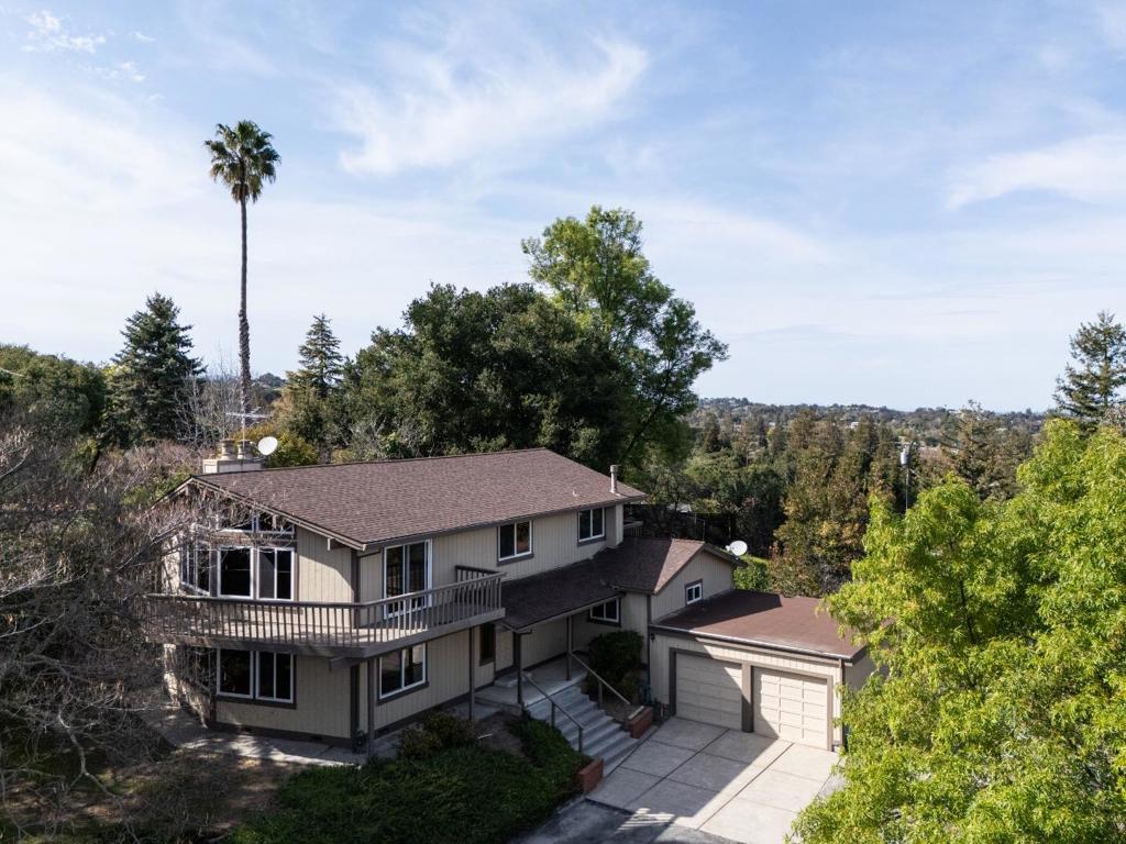 Privately situated at the end of a quiet lane on approximately one acre, this property presents an outstanding opportunity to renovate or build new in a premier close-in location. Elevated views stretch across the Bay and East Bay hills, providing a stunning backdrop for future possibilities. The existing two-story home features 4 bedrooms and 3 baths, highlighted by vintage details, expansive windows, and view decks. A long driveway ensures privacy in this neighborhood of surrounding estate properties. Less than a mile from Highway 280 and from Rancho San Antonio trails, with access to top-rated Los Altos schools, this is an exceptional offering with wonderful potential.