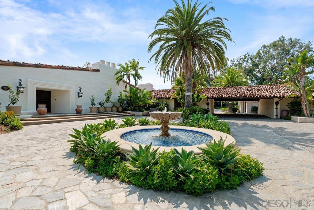 Experience the essence of timeless California ranch-style living in this architectural masterpiece designed by Cliff May. Recently refreshed, this stunning single-level estate, located in the prestigious Rancho Santa Fe Covenant, offers captivating views of rolling hills and glimpses of the golf course. The property spans over 10,000 square feet of luxurious living space on a sprawling 3-acre lot surrounded by lush greenery and mature trees. Step inside to a grand foyer that leads to elegant formal living and dining rooms, a gourmet kitchen, a family room, a wood-paneled office, and a state-of-the-art theatre. The gourmet kitchen is a chef’s dream, equipped with top-of-the-line appliances. Three additional bedroom suites provide ultimate comfort for family and guests. Outdoors, enjoy beautifully landscaped grounds, a sparkling pool and spa, and multiple seating areas perfect for entertaining or peaceful relaxation. This rare single-level estate offers an unmatched opportunity in one of Southern California’s most desirable neighborhoods. With easy access to world-class golf courses, tennis clubs, equestrian facilities, and scenic hiking and biking trails, this home embodies luxury and leisure at its finest.