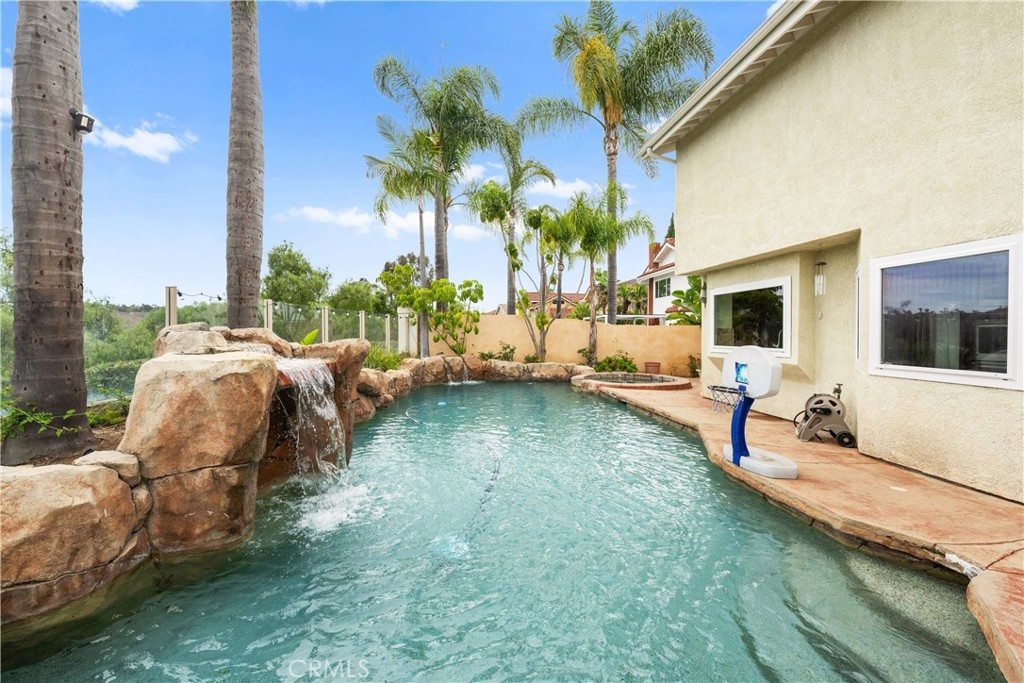 YOUR OWN PRIVATE OASIS AWAITS! Perfectly placed at the end of a quiet cul-de-sac, this property offers a massive lot with sweeping mountain and city-light vistas. Whether you’re hosting gatherings or enjoying quiet evenings, the setting delivers both privacy and breathtaking scenery. You even have fully paid solar with this gem of a home!
Step through the ornate iron double doors into a dramatic entry with soaring ceilings that immediately set the tone. To one side, the formal living and dining rooms welcome elegant entertaining. To the other, a warm and inviting family room with a fireplace creates the ideal spot to unwind while soaking in unobstructed views.
The kitchen is designed for both everyday living and culinary adventures, featuring a sunny breakfast nook, generous counter space, rich cabinetry, granite counters, and premium stainless-steel appliances—including a six-burner cooktop, double oven, and oversized refrigerator.
Outdoors, the backyard is nothing short of a resort escape—a custom pool with cascading waterfalls, relaxing spa, built-in BBQ, and tropical landscaping accented by tall palms. Fruit trees flourish throughout the property, from apple and lemon to pomegranate, persimmon, fig, and more.
Inside, thoughtful upgrades enhance the home: newer windows, engineered wood floors, marble-tiled baths, and crown molding details throughout. A main-level bedroom and bath add valuable flexibility, while upstairs the primary suite and several rooms enjoy incredible views.
With low HOA fees, low taxes, award-winning schools nearby, and just minutes to Southern California’s finest beaches, this home blends comfort, elegance, and convenience in one unforgettable package.