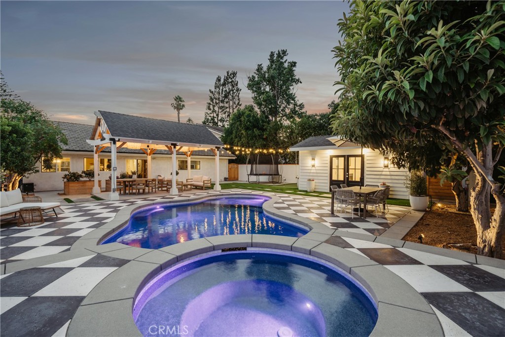 Prepare to fall in love...Tucked into a quiet cul-de-sac, this single-level stunner delivers style, soul, and smart functionality at every turn. Gutted and reimagined, it’s a design-forward dream with all the right vibes. The main home features 3 bedrooms and 2 beautifully remodeled bathrooms, including a gorgeous primary suite with a spa-like bath- featuring a freestanding soaking tub, designer finishes, and a walk-in shower that feels straight out of a magazine. A newly built and totally dialed-in ADU adds even more versatility, bringing the total to 4 beds and 3 baths. With vaulted tongue-and-groove vaulted ceilings, fireplace, zellige tile, kitchenette, and bonus plumbing hookups, it’s a dreamy flex space- guest suite, studio, gym, or office? You choose. From the bold black-and-white checkerboard concrete hardscape to the new pool + spa, every inch is curated for California living. Enjoy vaulted ceilings, a remodeled kitchen, newer Milgard dual-pane windows, updated HVAC, custom patio cover, private putting green, and a fenced-in front yard perfect for pets or play. TURN-KEY. ON-TREND. FULL OF VIBES. Assigned to top-rated Tustin schools, and ready to impress.