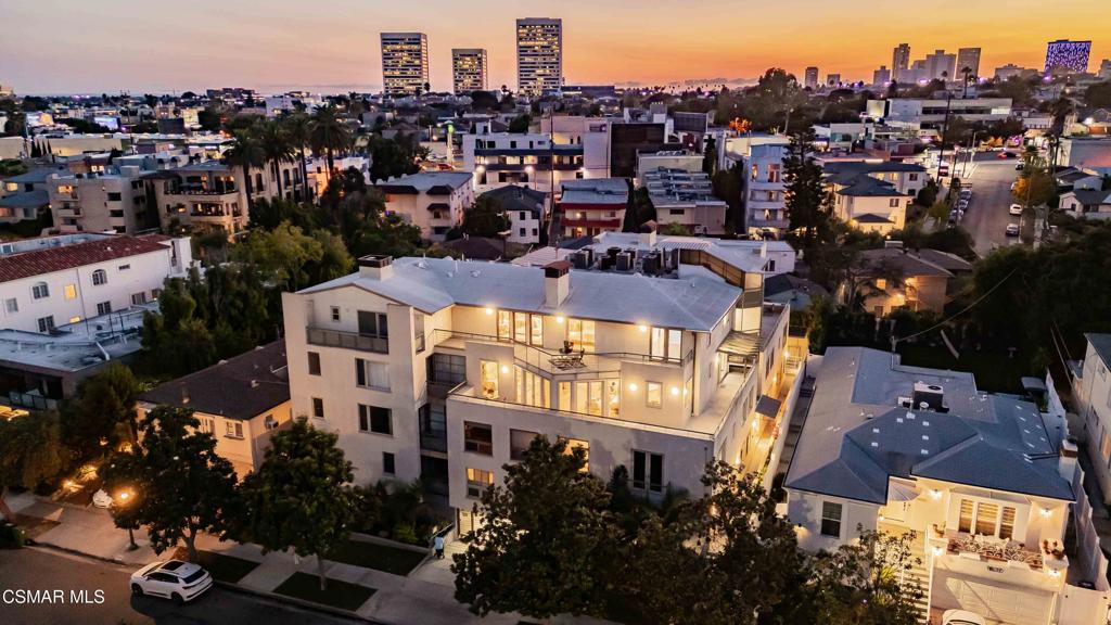 First Time on Market - Luxury Townhome in the Heart of Westwood! This stunning home is offered to purchase for the very first time. Nestled on one of the most beautiful tree-lined streets in the area, this impressive property sits on the 3rd floor of the exclusive Mayflower Villas, offering gorgeous treetop and city views. With over 2,800 sqft of living space and a massive wraparound balcony, natural sunlight floods every room through large windows and French doors. Elegant curves and high-end finishes define the home--from the custom kitchen cabinetry, Thermador appliances, and multiple marble fireplaces, to the sculptural staircase that makes a true architectural statement. The main level features a light, neutral interior with hardwood floors throughout, a spacious bedroom with en suite bath, and a fantastic floorplan that includes dual fireplaces in both the family and living rooms, a formal dining room, and powder bath. The gourmet kitchen offers two Sub-Zero refrigerators, an island with seating, a breakfast bar, walk-in pantry, and a full wall of windows with direct access to your wraparound balcony. Upstairs, a versatile loft area is perfect for work or play, complemented by a convenient laundry room and oversized skylights. Two guest bedrooms are generously sized, each with en suite baths and walk-in closets. The primary suite is expansive, featuring a marble fireplace, French doors leading to a private upper balcony, and a luxurious bath with marble finishes, dual vanities, a steam shower, and sunken tub. The oversized walk-in closet includes custom organizers. Additional highlights include American Vision windows and doors, a $10,000 custom kabob grill, fresh interior paint, and four garage parking spaces. With only 10 townhomes in the building, Mayflower Villas offers a private, controlled-access lobby with elevator, a meeting room, newly remodeled gym, pool, and multiple outdoor gathering areas. Low HOA dues. A rare opportunity to own a spacious and stylish townhome in one of Westwood's most desirable addresses.