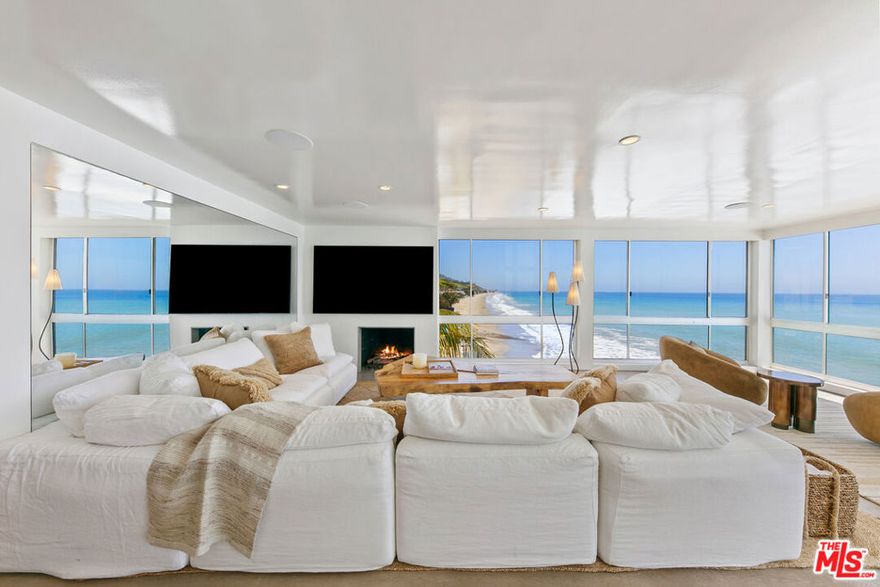 Discover the ultimate in coastal sophistication at this stunning oceanfront residence on Carbon Beach, located within Malibu's exclusive "Outrigger" complex. Offering private access to a sandy beach, along with a pool and spa reserved solely for residents, this home delivers true resort-style living just steps from Malibu's most iconic spots, including Nobu, Soho House, and the Malibu Pier. Expansive floor-to-ceiling glass walls capture uninterrupted, panoramic views of the ocean and coastline from every room even the spa-like primary bathroom. Fall asleep to the rhythm of the waves and wake up to breathtaking sunsets from the comfort of your bed. This sun-drenched two-bedroom, two-bath retreat features custom French white oak flooring and high-end finishes throughout. Designed for effortless indoor-outdoor living, the open layout flows seamlessly onto a private patio perfect for quiet mornings or warm summer evenings by the sea.